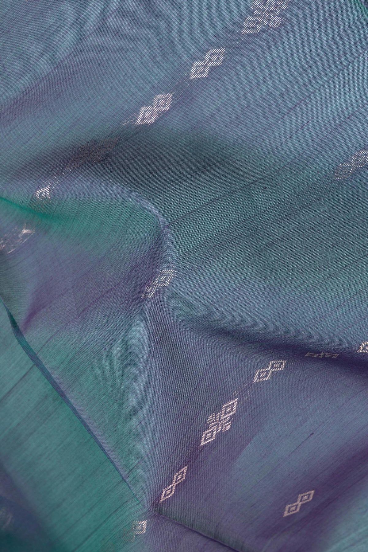 Close up of Peacock Blue Dual Tone Silk Cotton Saree with Zari Butta on the body and Zari Border.  displaying folds