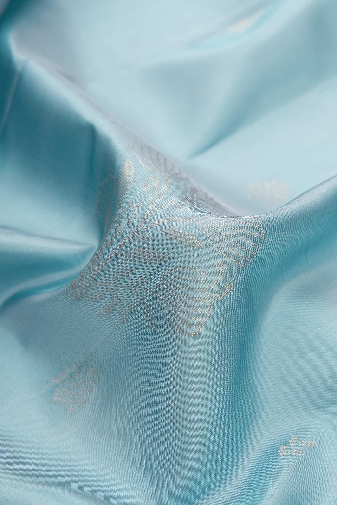Close up of Grey Dual Tone Soft Silk Saree with Zari Butta on the body and Zari Border.  displaying folds