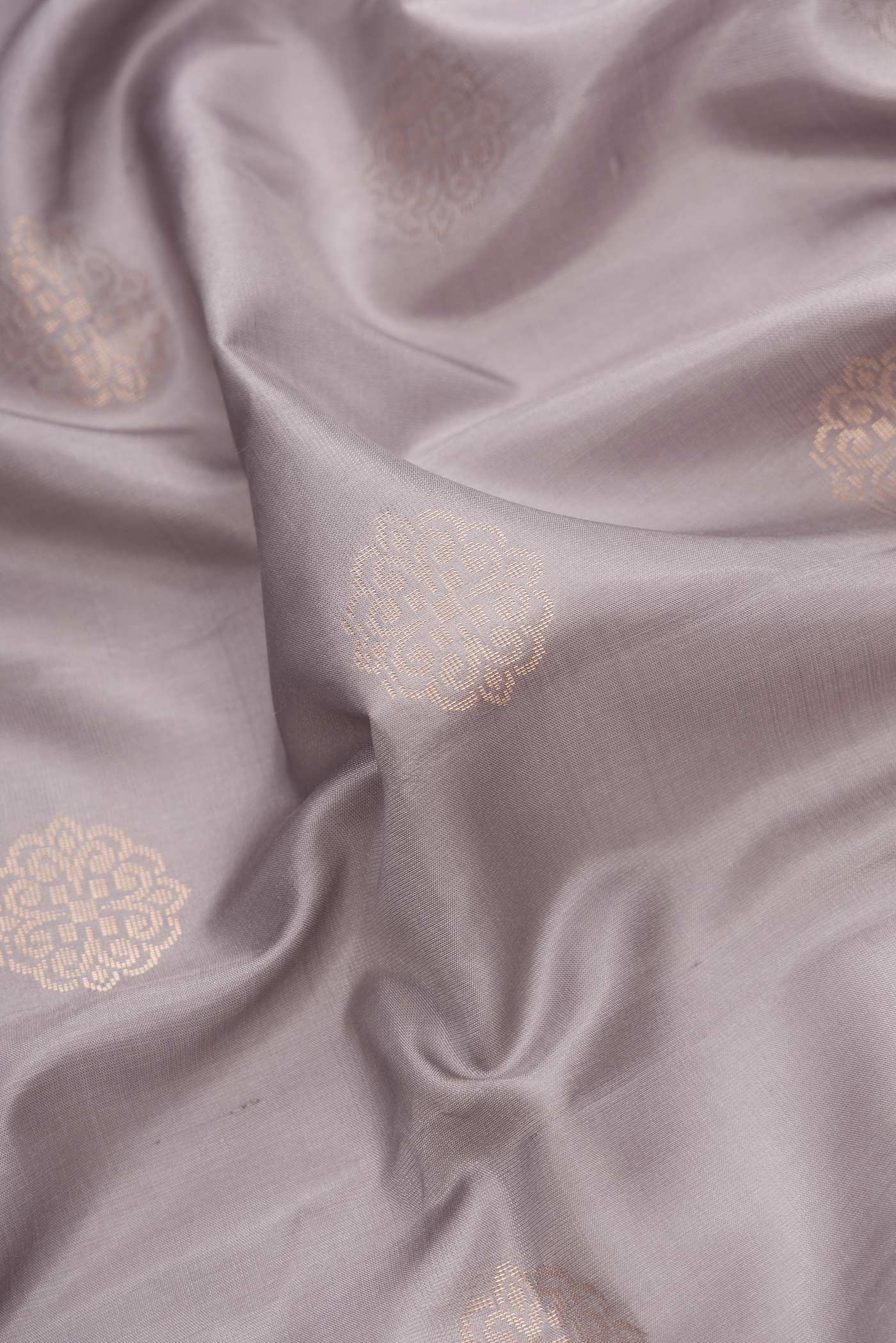 Close up of Grey Dual Tone Soft Silk Saree with Zari Butta on the body and Fancy Border.  displaying folds