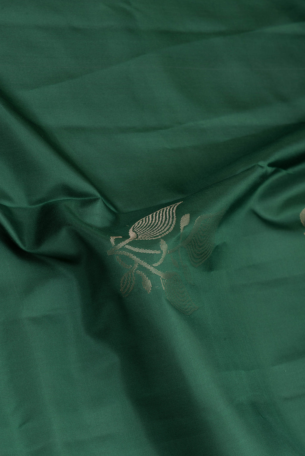 Close up of Bottle Green Soft Silk Saree with Zari Butta on the body and Plain Border.  displaying folds
