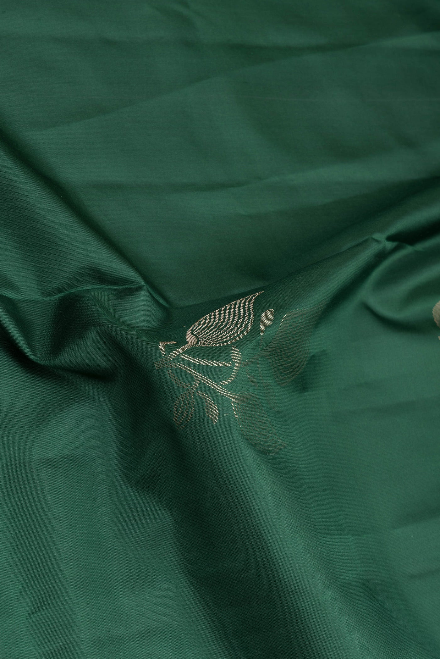 Close up of Bottle Green Soft Silk Saree with Zari Butta on the body and Plain Border.  displaying folds