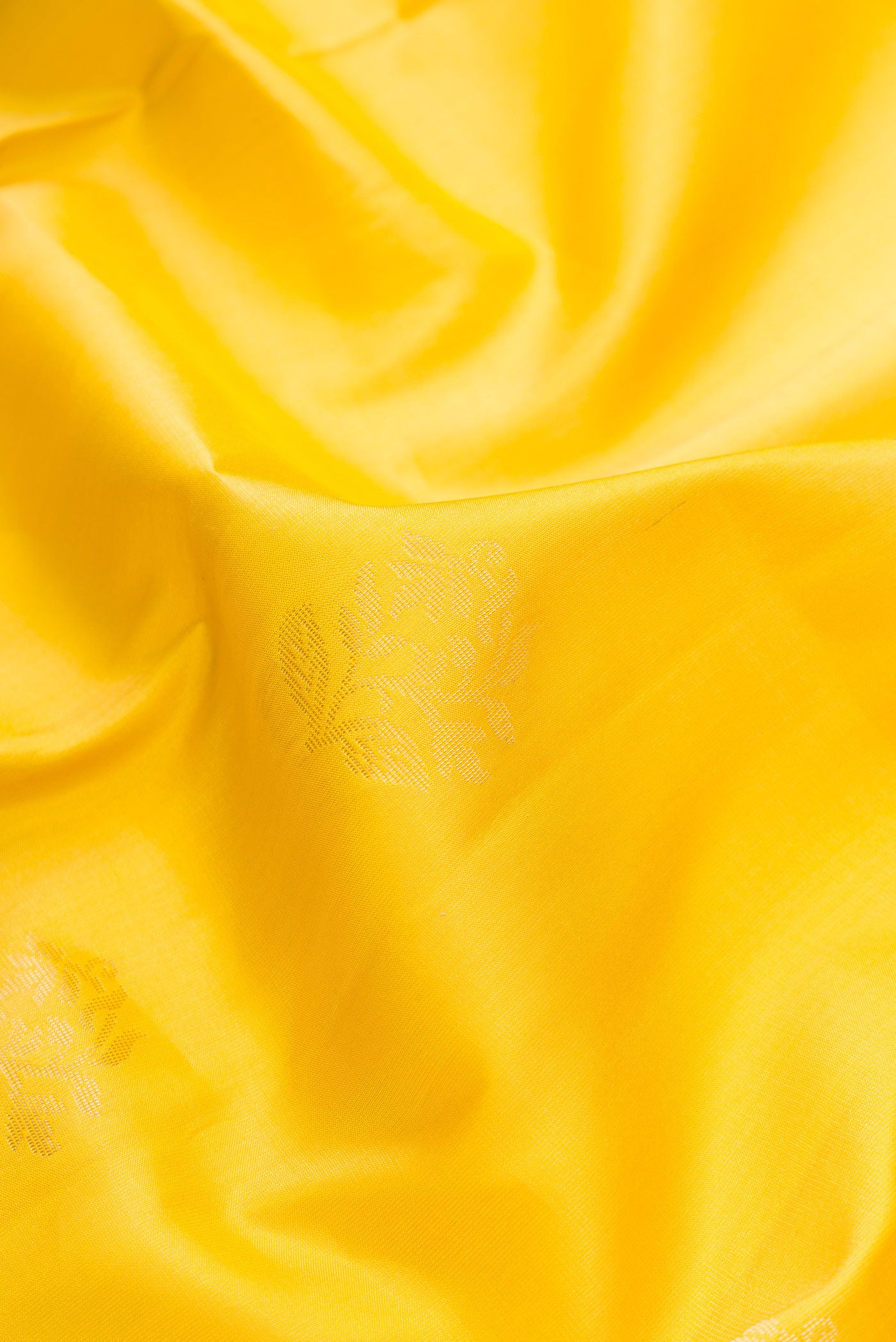 Close up of Mustard Dual Tone Soft Silk Saree with Zari Butta on the body and Zari Border.  displaying folds