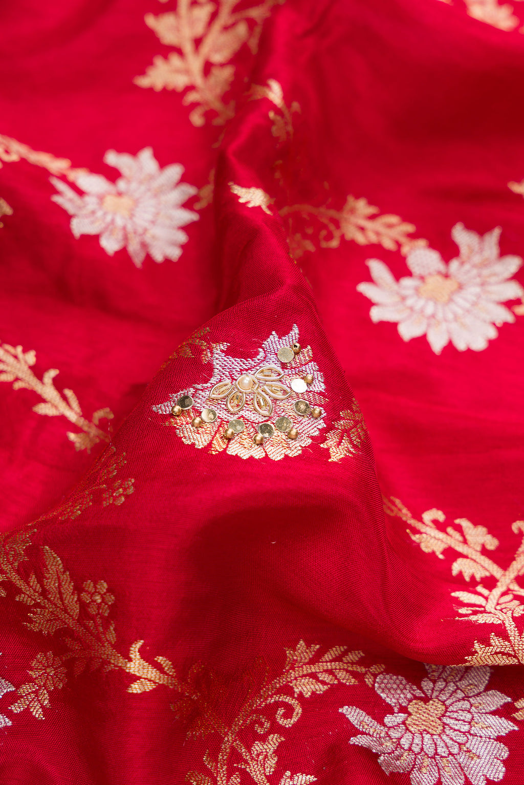 Close up of Red Dual Tone Georgette Saree with Zari Brocade on the body and Embroidery Border.  displaying folds