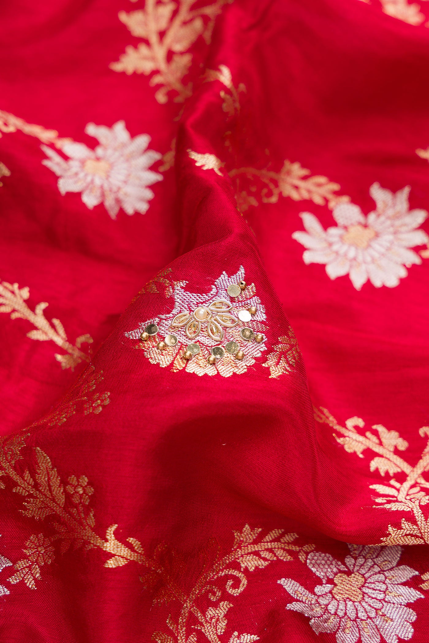 Close up of Red Dual Tone Georgette Saree with Zari Brocade on the body and Embroidery Border.  displaying folds