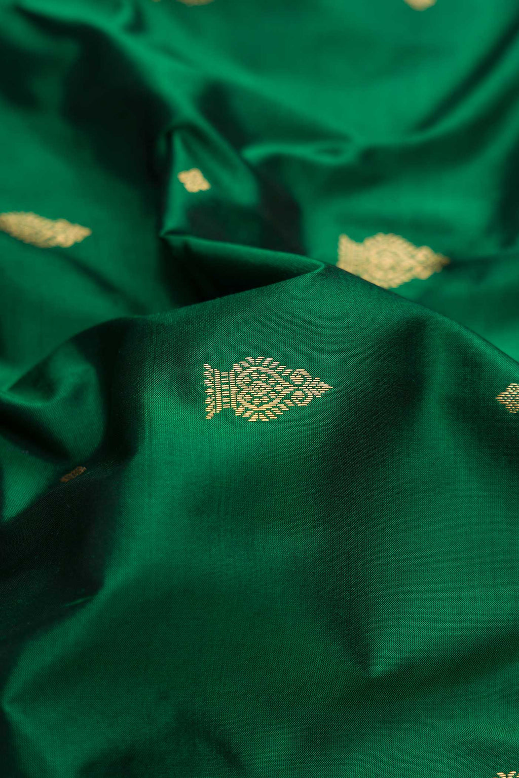 Close up of Bottle Green Dual Tone Kanchipuram Silk Saree with Zari Butta on the body and Temple Border.  displaying folds