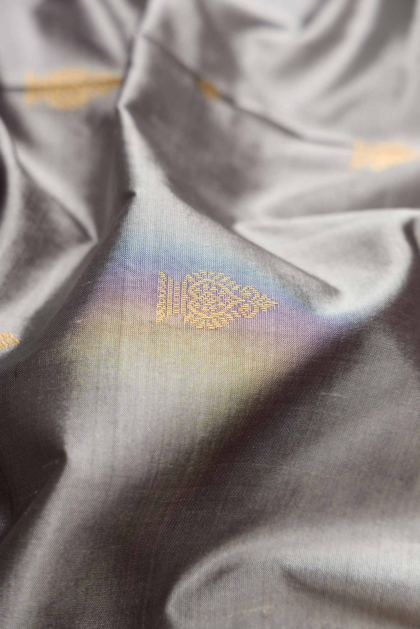 Close up of Grey Dual Tone Kanchipuram Silk Saree with Zari Butta on the body and Temple Border.  displaying folds