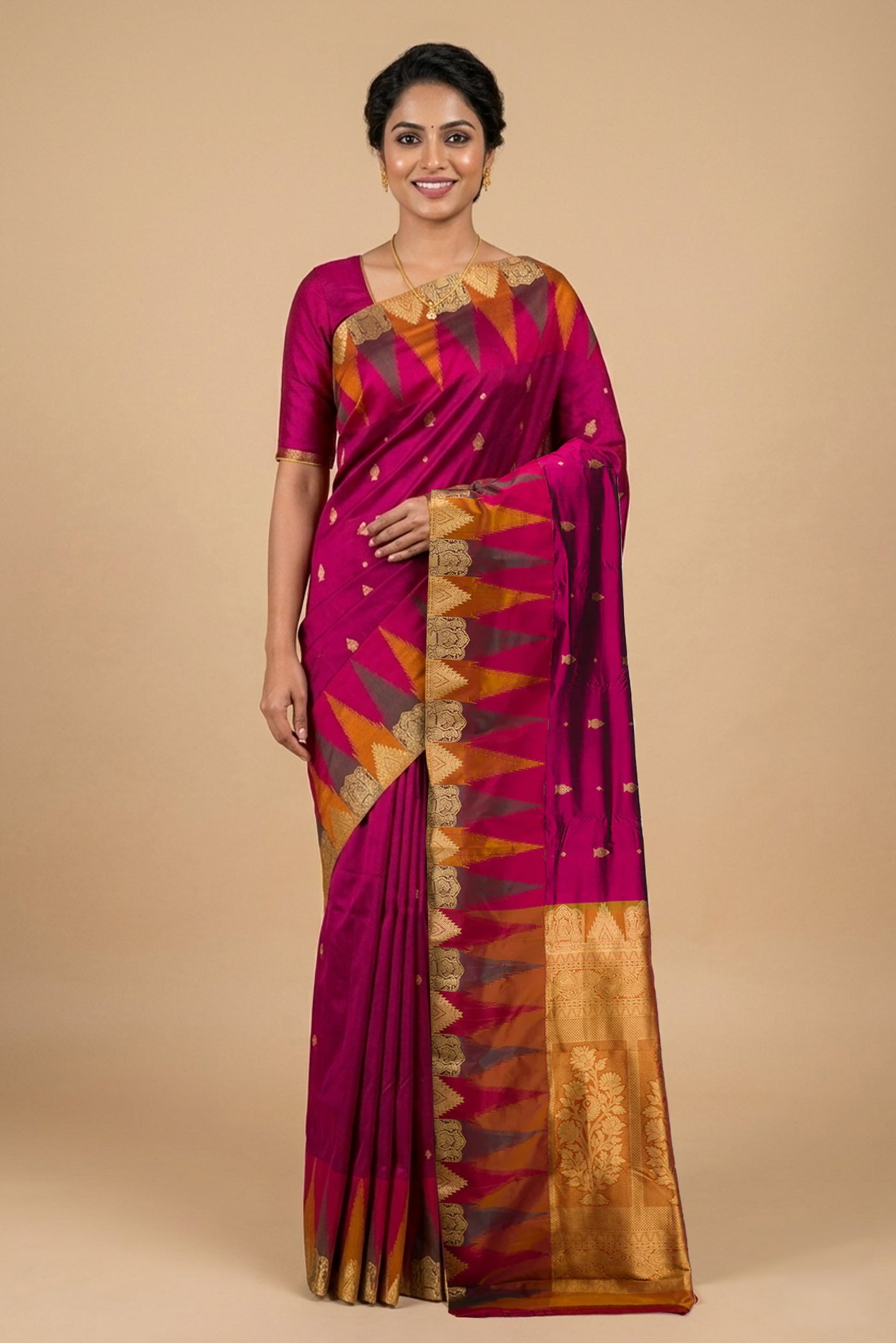 Model wearing a Magenta Bangalore Silk Saree with Zari Butta on the body and Temple Border.