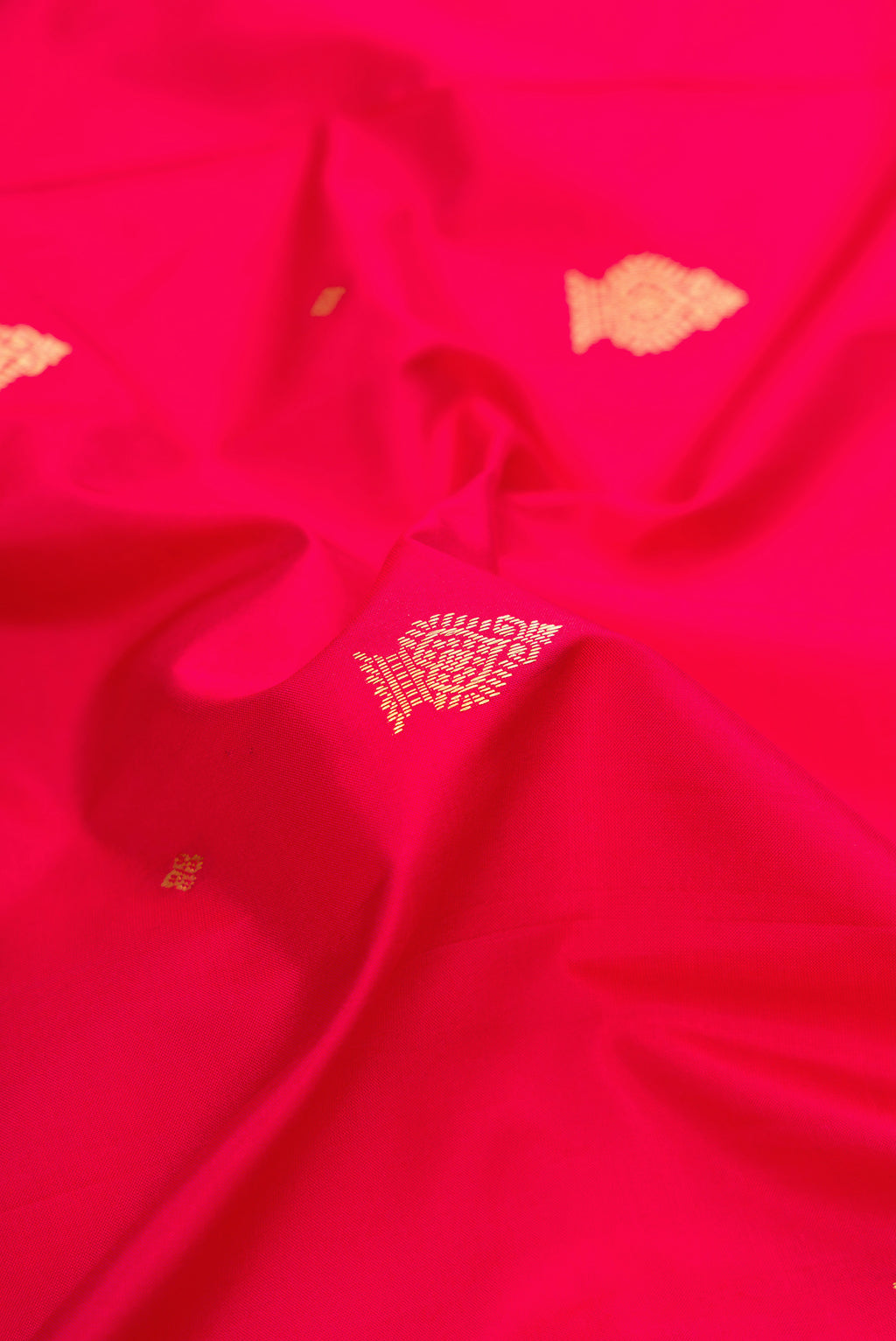 Close up of Red Dual Tone Kanchipuram Silk Saree with Zari Butta on the body and Temple Border.  displaying folds