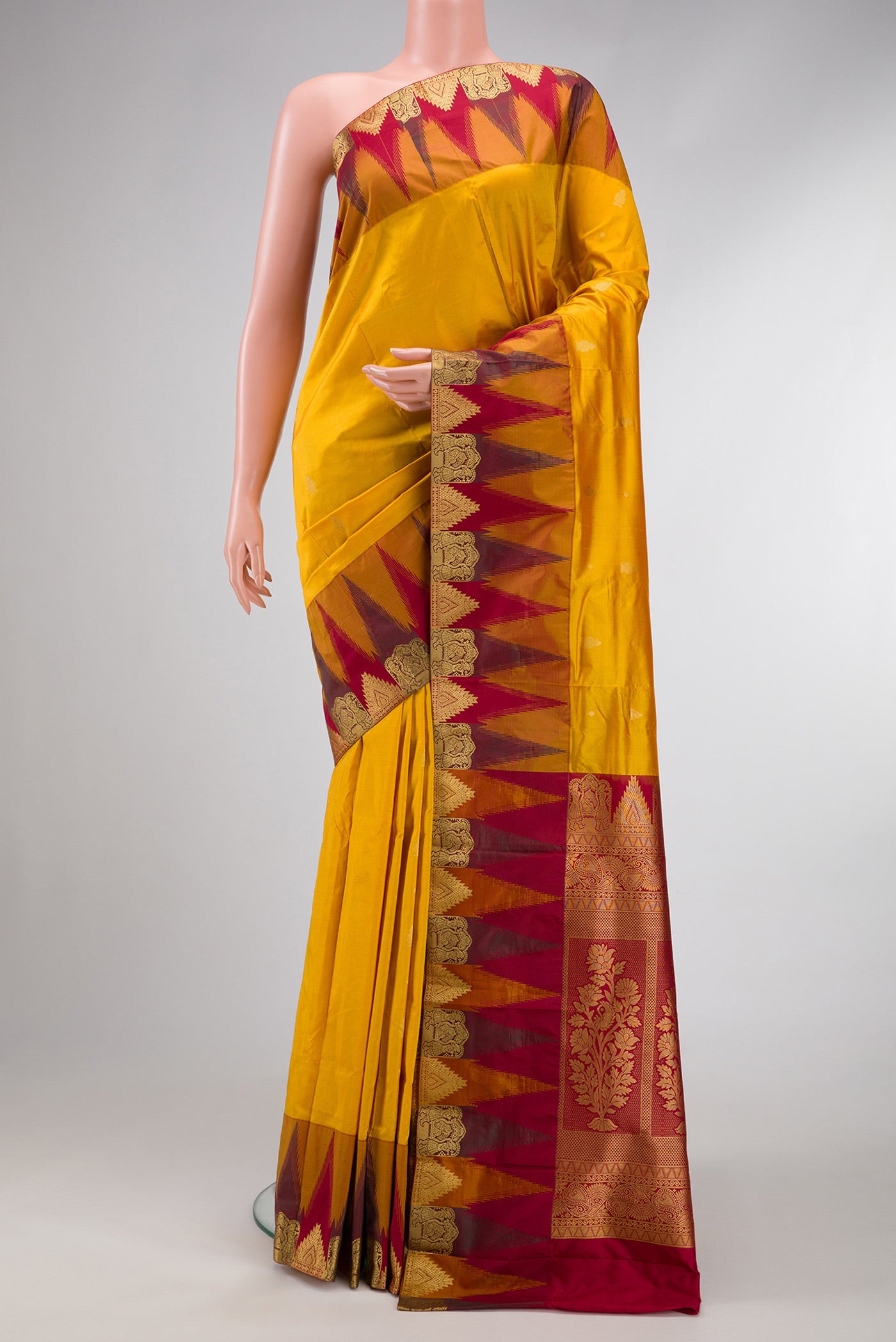 Mustard Dual Tone Kanchipuram Silk Saree with Zari Butta on the body and Temple Border.  displayed on a mannequin