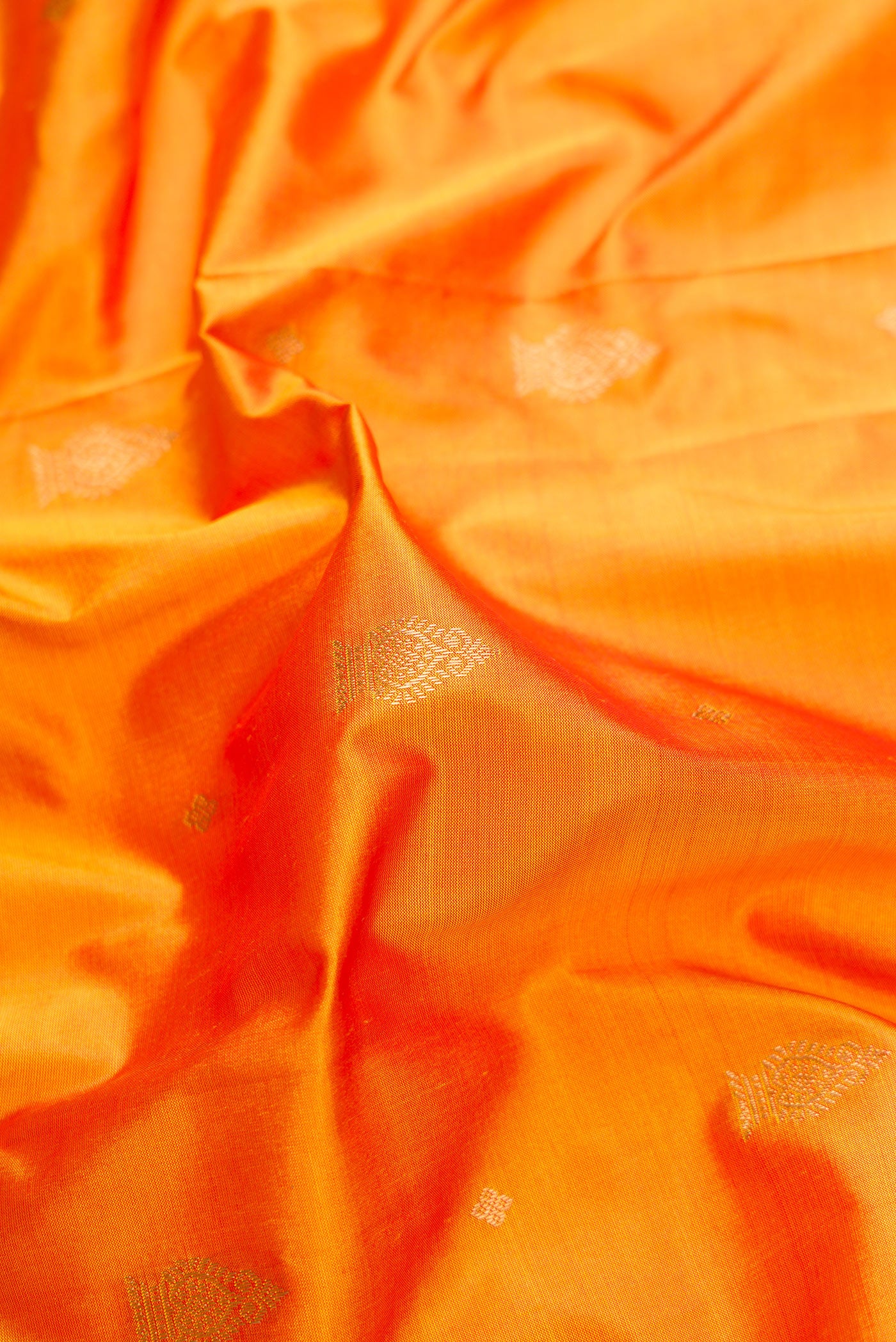 Close up of Mustard Dual Tone Kanchipuram Silk Saree with Zari Butta on the body and Temple Border.  displaying folds