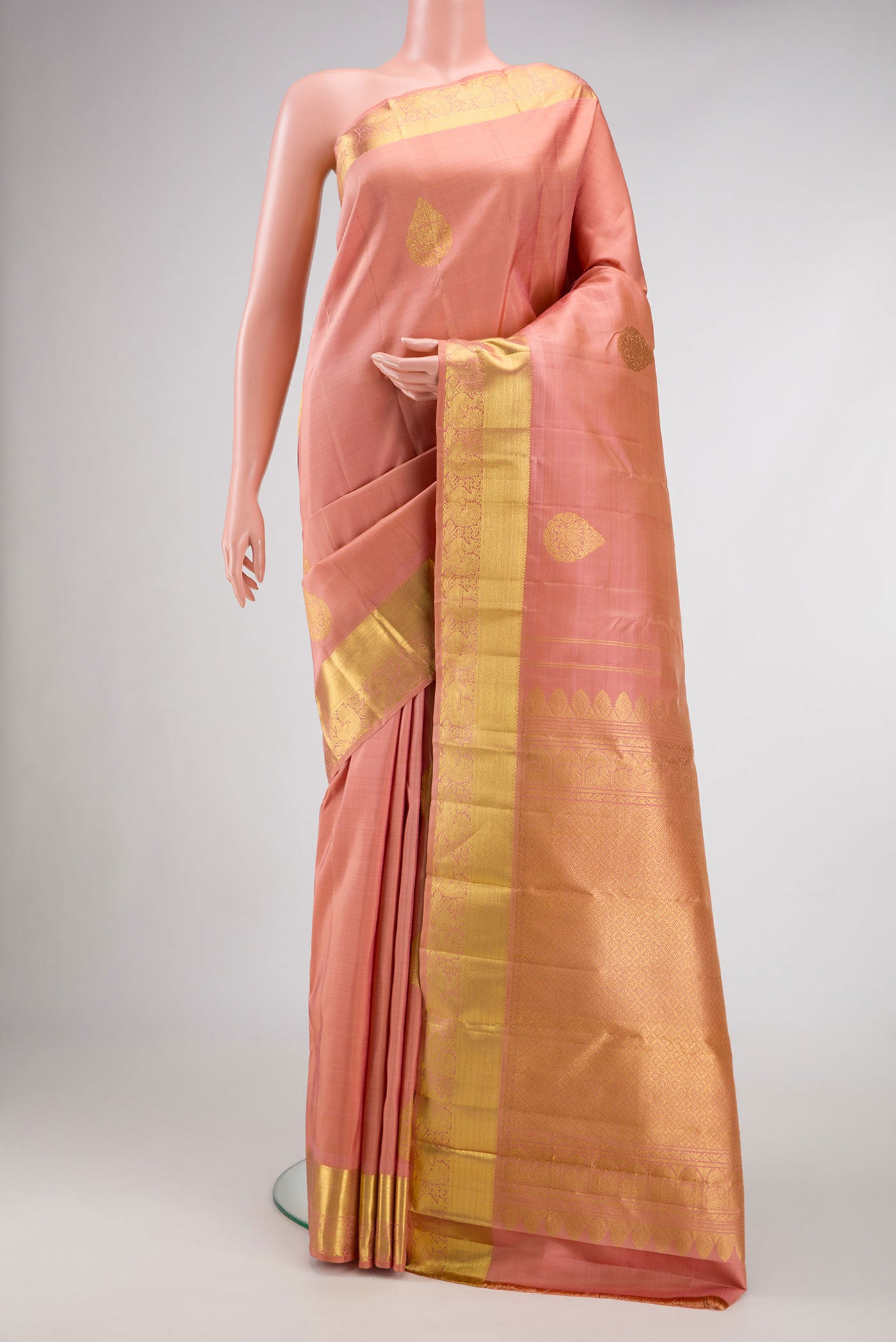 Rose Gold Dual Tone Kanjivaram Silk Saree with Zari Butta on the body and Zari Border.  displayed on a mannequin
