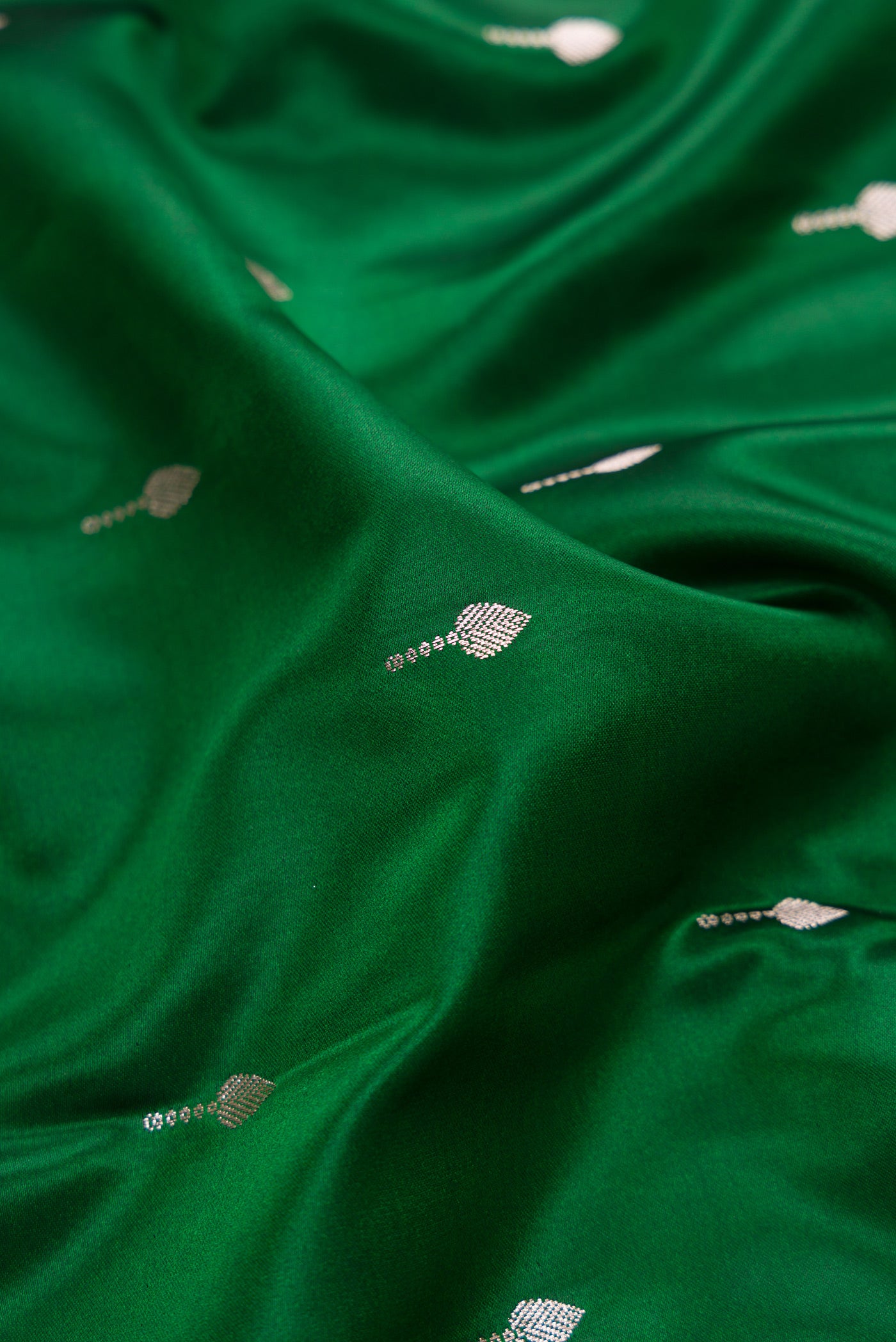 Close up of Bottle Green Dual Tone Banarasi Silk Saree with Zari Butta on the body and Zari Border.  displaying folds