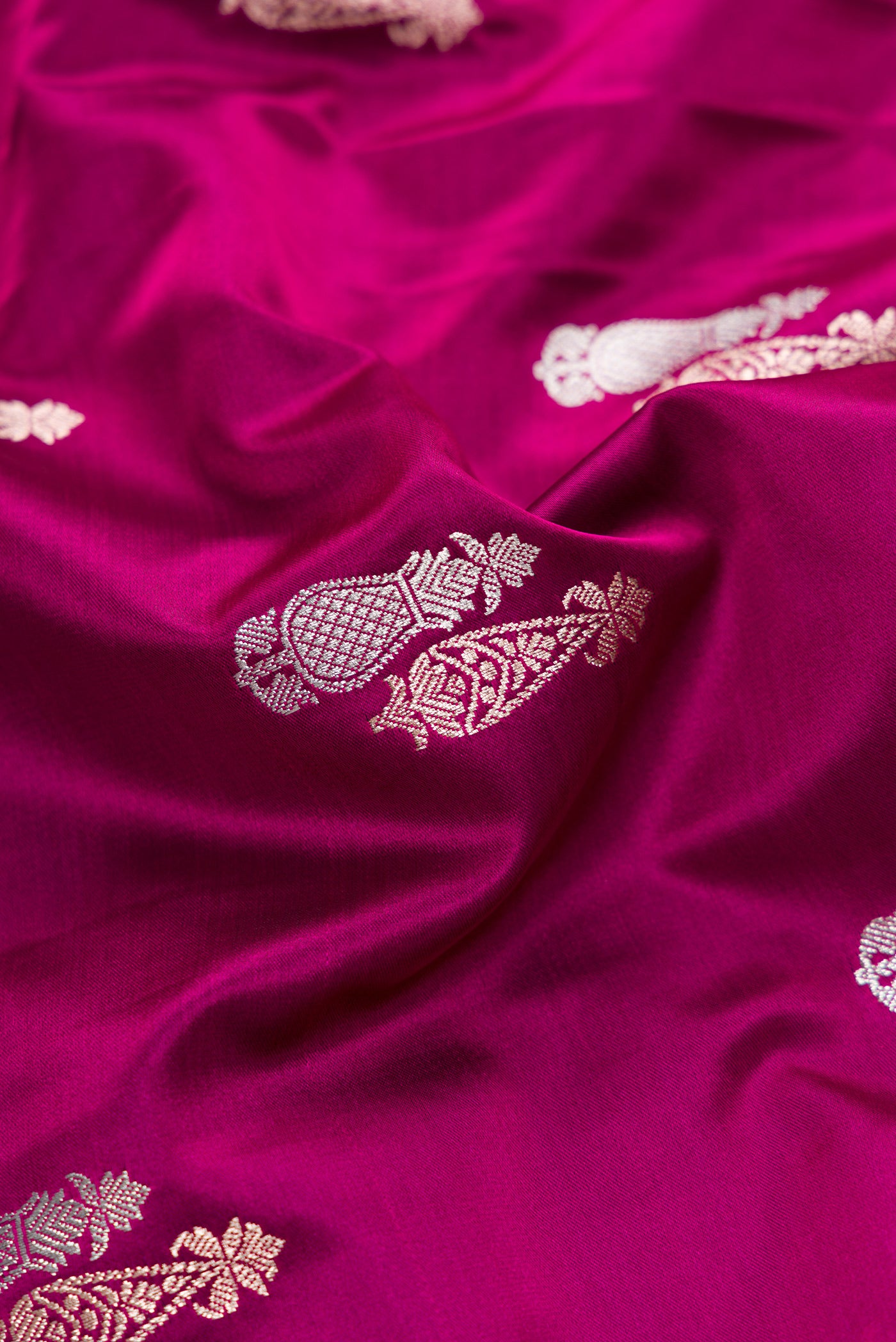 Close up of Burgundy Dual Tone Banarasi Silk Saree with Zari Butta on the body and Zari Border.  displaying folds