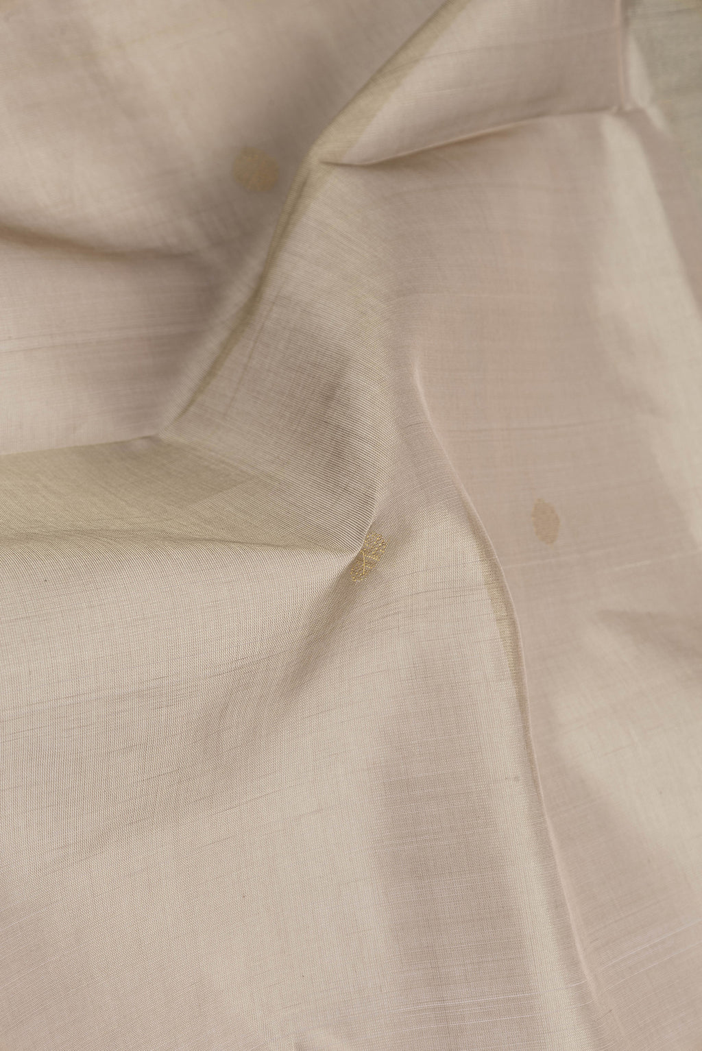 Close up of Dark Beige Silk Cotton Saree with Zari Butta on the body and Zari Border.  displaying folds