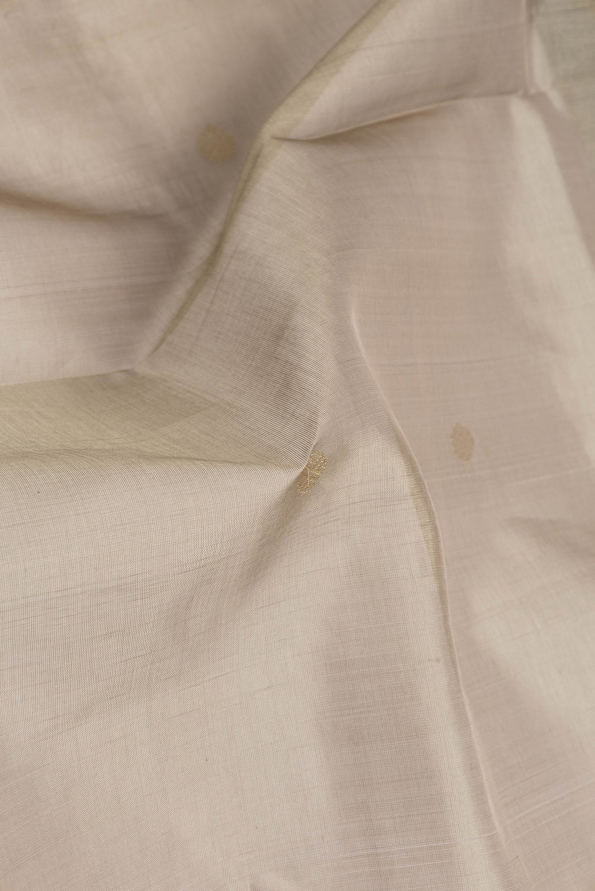 Close up of Dark Beige Silk Cotton Saree with Zari Butta on the body and Zari Border.  displaying folds