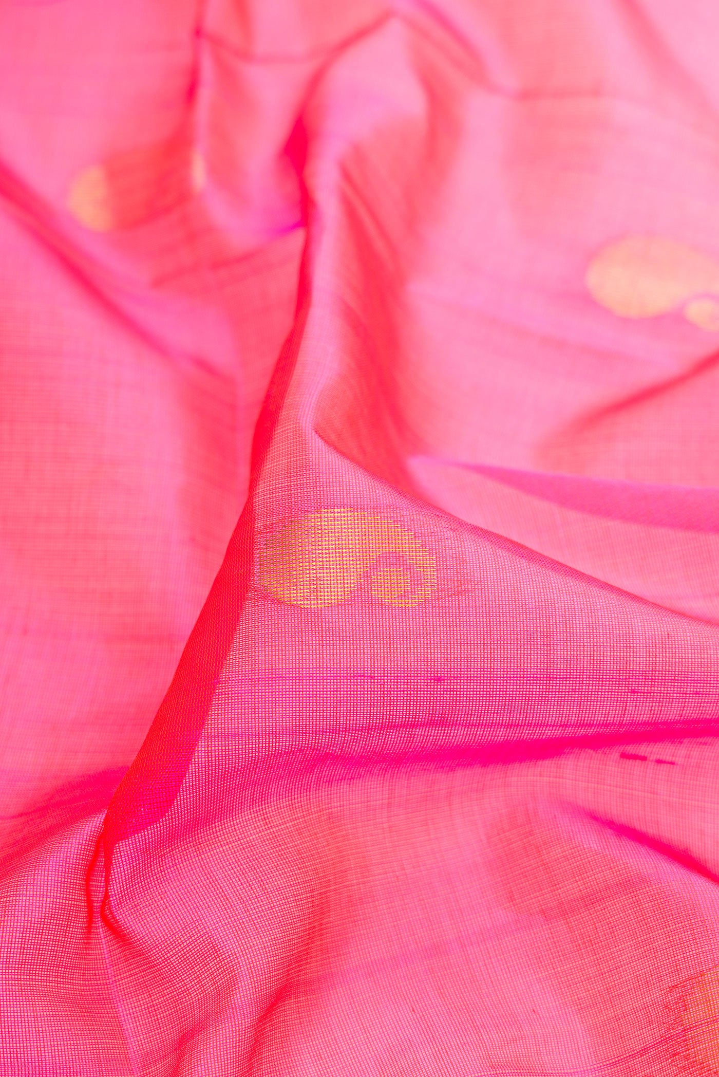Close up of Pink Silk Cotton Saree with Zari Butta on the body and Zari Border.  displaying folds