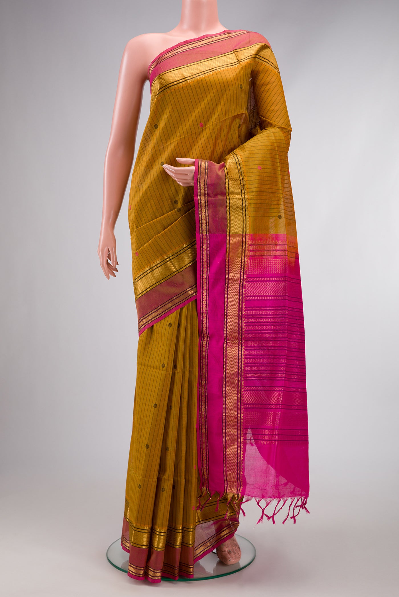 Mustard Silk Cotton Saree with Stripes on the body and Zari Border.  displayed on a mannequin