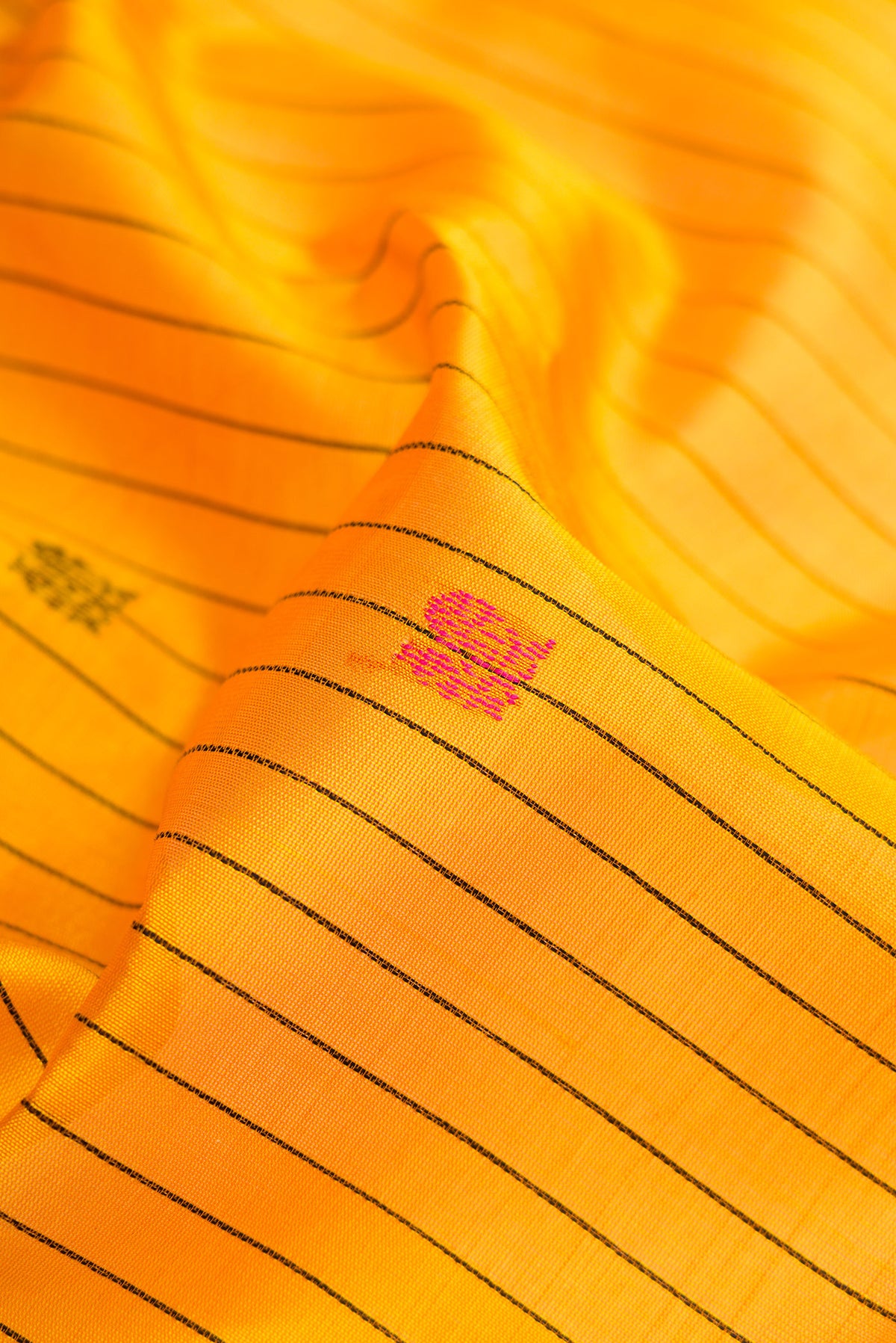 Close up of Yellow Silk Cotton Saree with Stripes on the body and Zari Border.  displaying folds