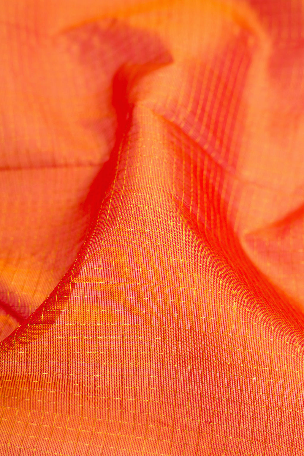Close up of Orange Dual Tone Silk Cotton Saree with Checked design on the body and Zari Border.  displaying folds