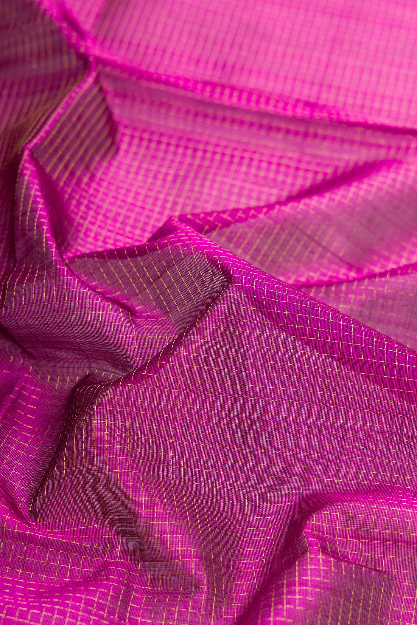 Close up of Magenta Dual Tone Silk Cotton Saree with Checked design on the body and Zari Border.  displaying folds