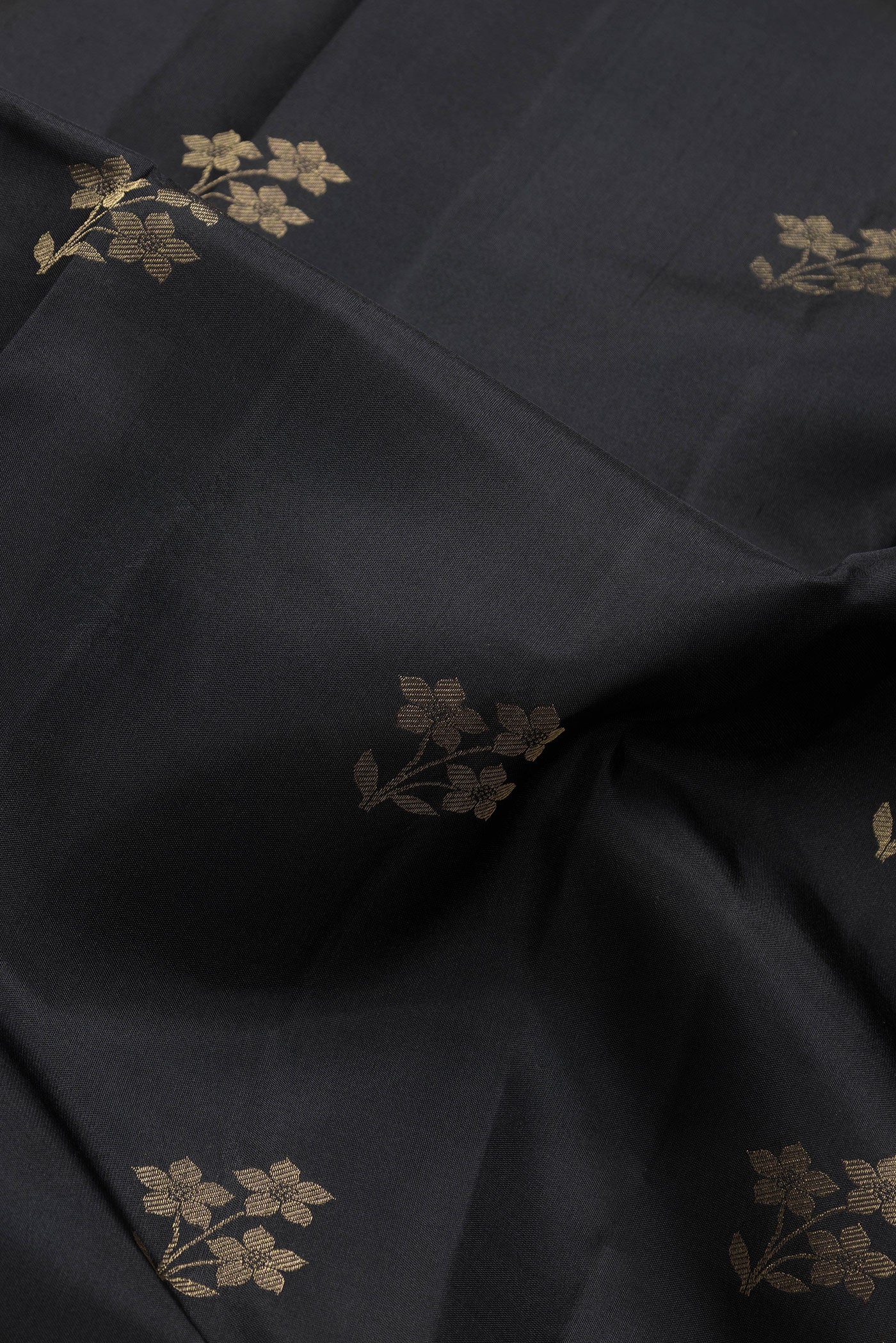 Close up of Black Dual Tone Kanjivaram Silk Saree with Zari Butta on the body and Zari Border.  displaying folds