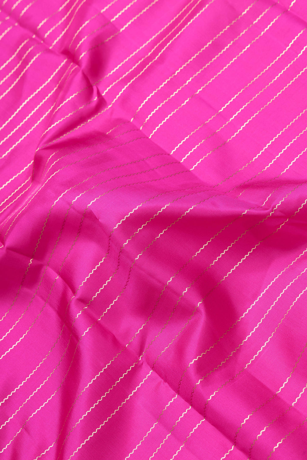 Close up of Pink Dual Tone Kanchipuram Silk Saree with Stripes on the body and Zari Border.  displaying folds