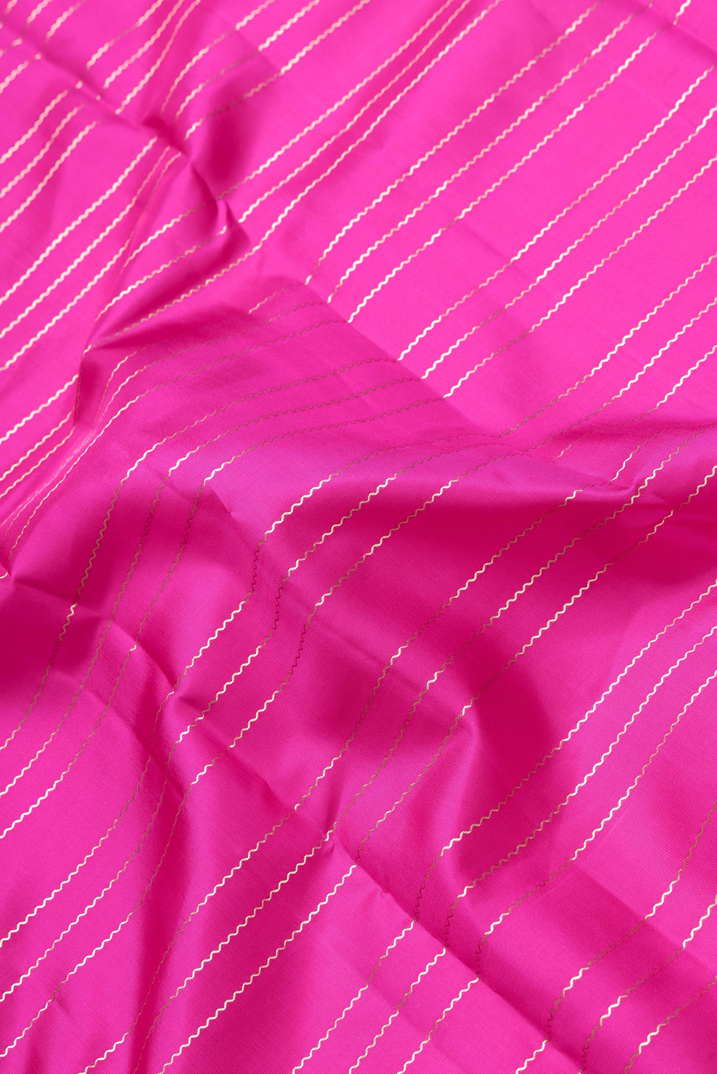 Close up of Pink Dual Tone Kanchipuram Silk Saree with Stripes on the body and Zari Border.  displaying folds