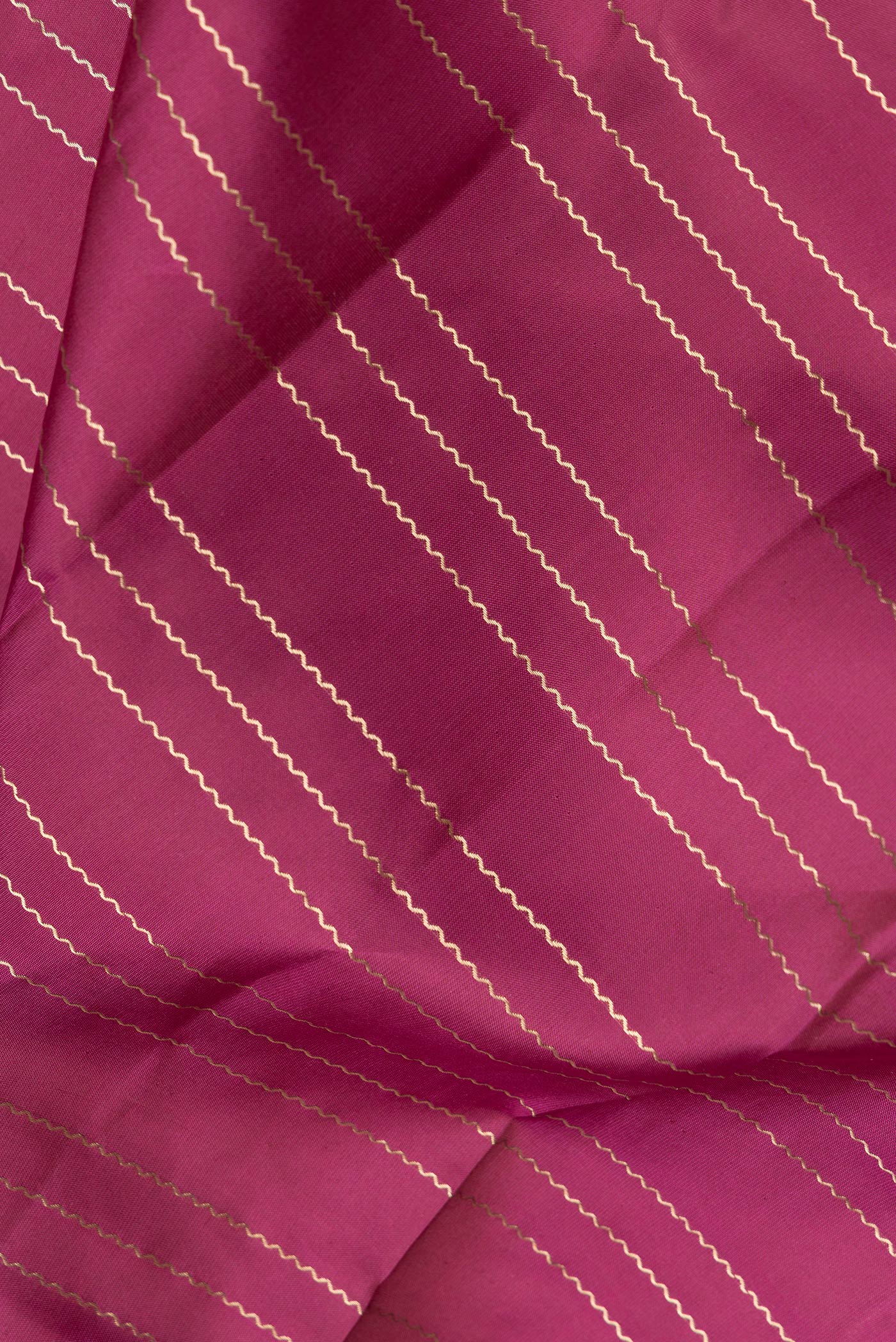 Close up of Magenta Dual Tone Kanchipuram Silk Saree with Stripes on the body and Zari Border.  displaying folds