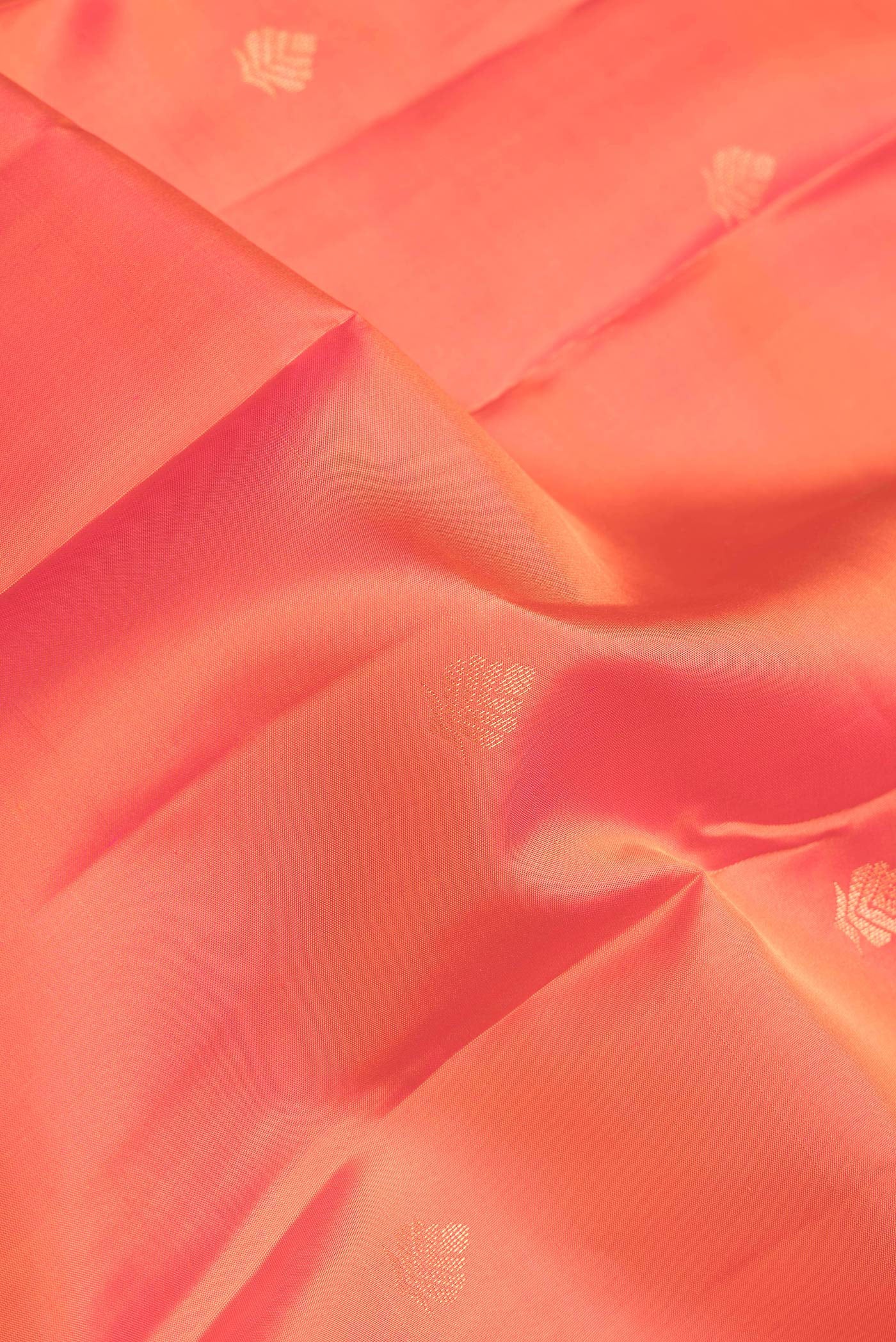Close up of Orange Dual Tone Kanchipuram Silk Saree with Zari Butta on the body and Zari Border.  displaying folds