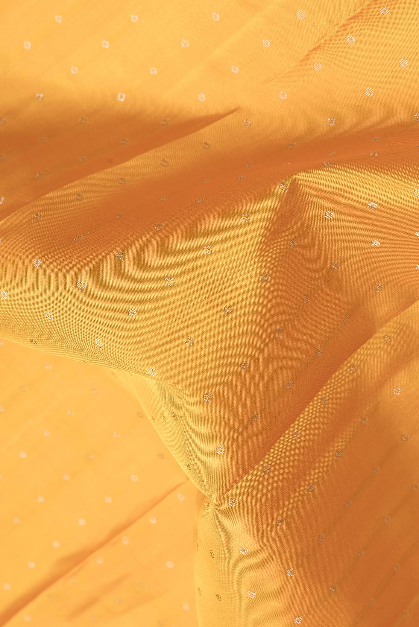 Close up of Mustard Dual Tone Kanchipuram Silk Saree with Zari Butta on the body and Zari Border.  displaying folds