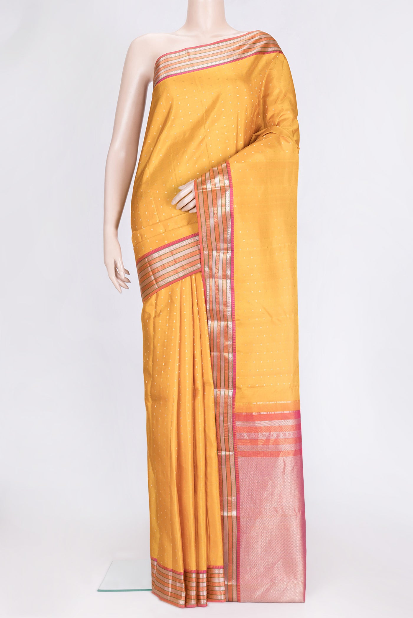 Mustard Dual Tone Kanchipuram Silk Saree with Zari Butta on the body and Zari Border.  displayed on a mannequin