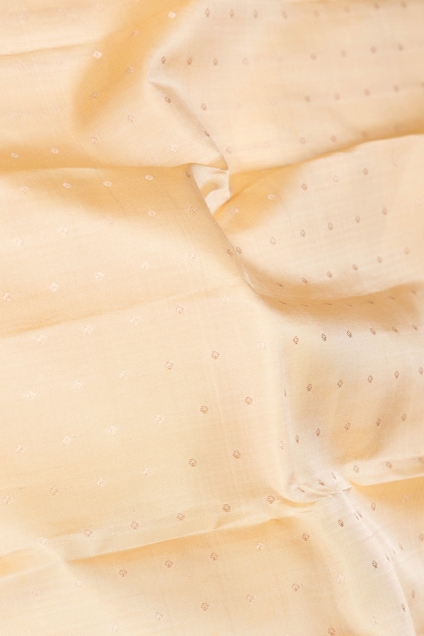 Close up of Beige Dual Tone Kanchipuram Silk Saree with Zari Butta on the body and Zari Border.  displaying folds