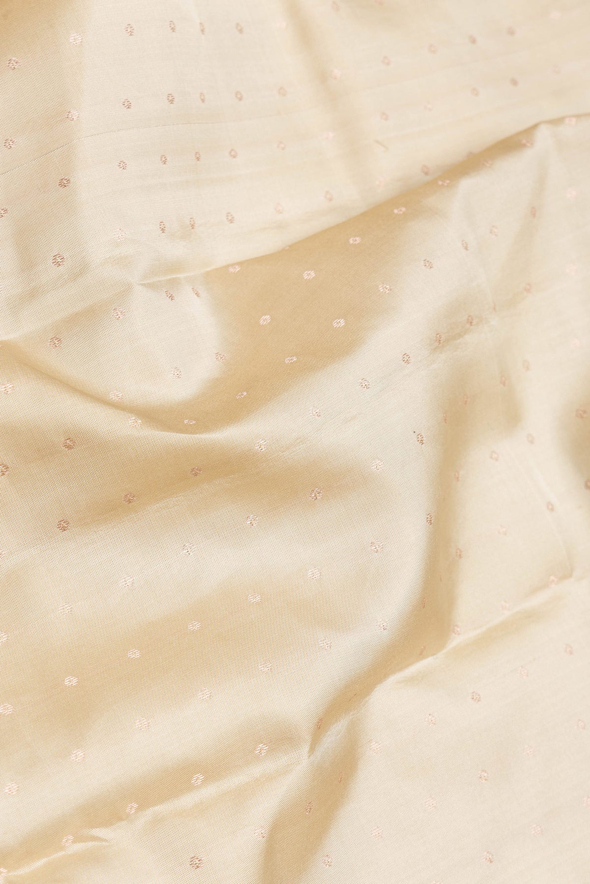 Close up of Beige Dual Tone Kanchipuram Silk Saree with Zari Butta on the body and Zari Border.  displaying folds