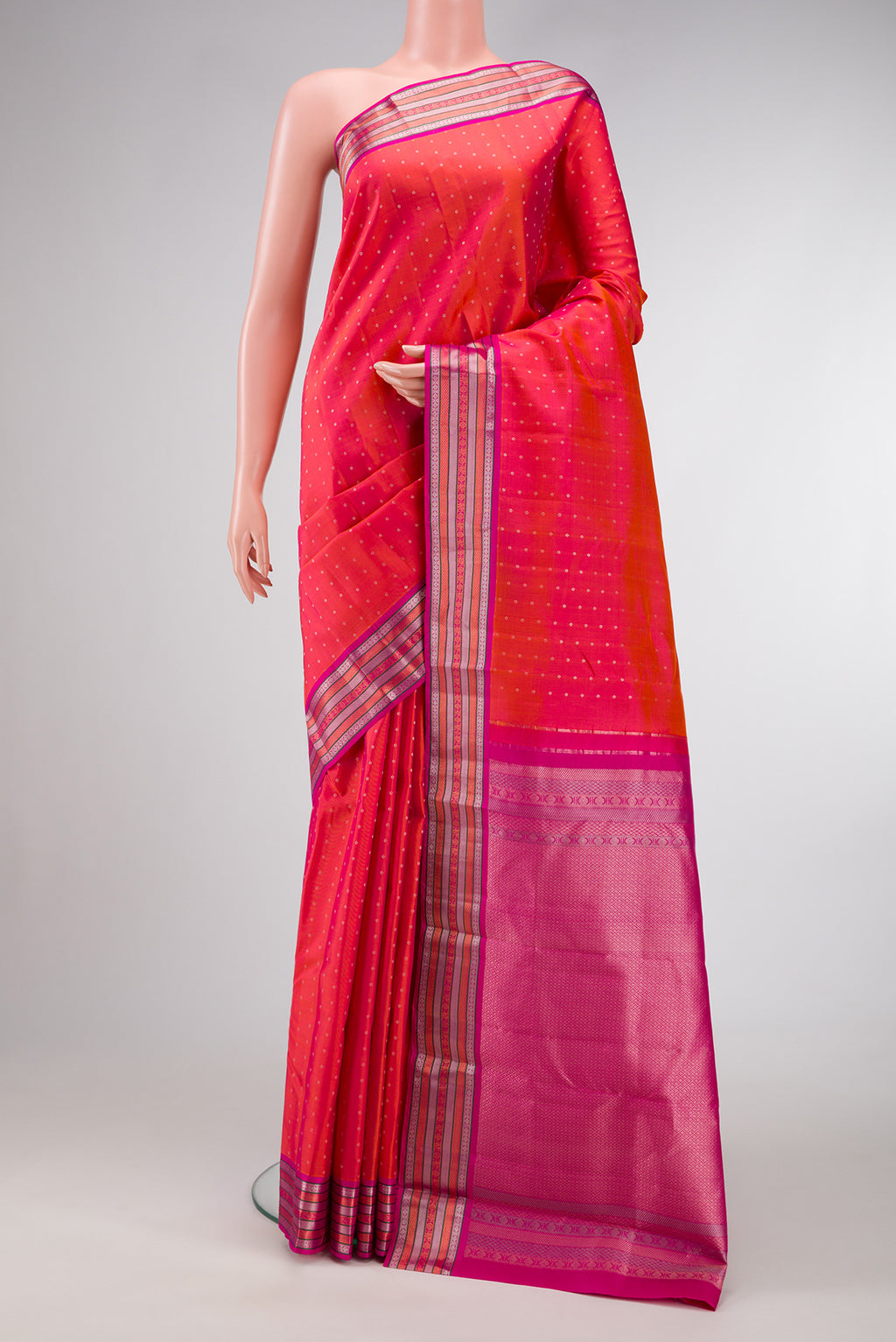 Coral Dual Tone Kanchipuram Silk Saree with Zari Butta on the body and Zari Border.  displayed on a mannequin