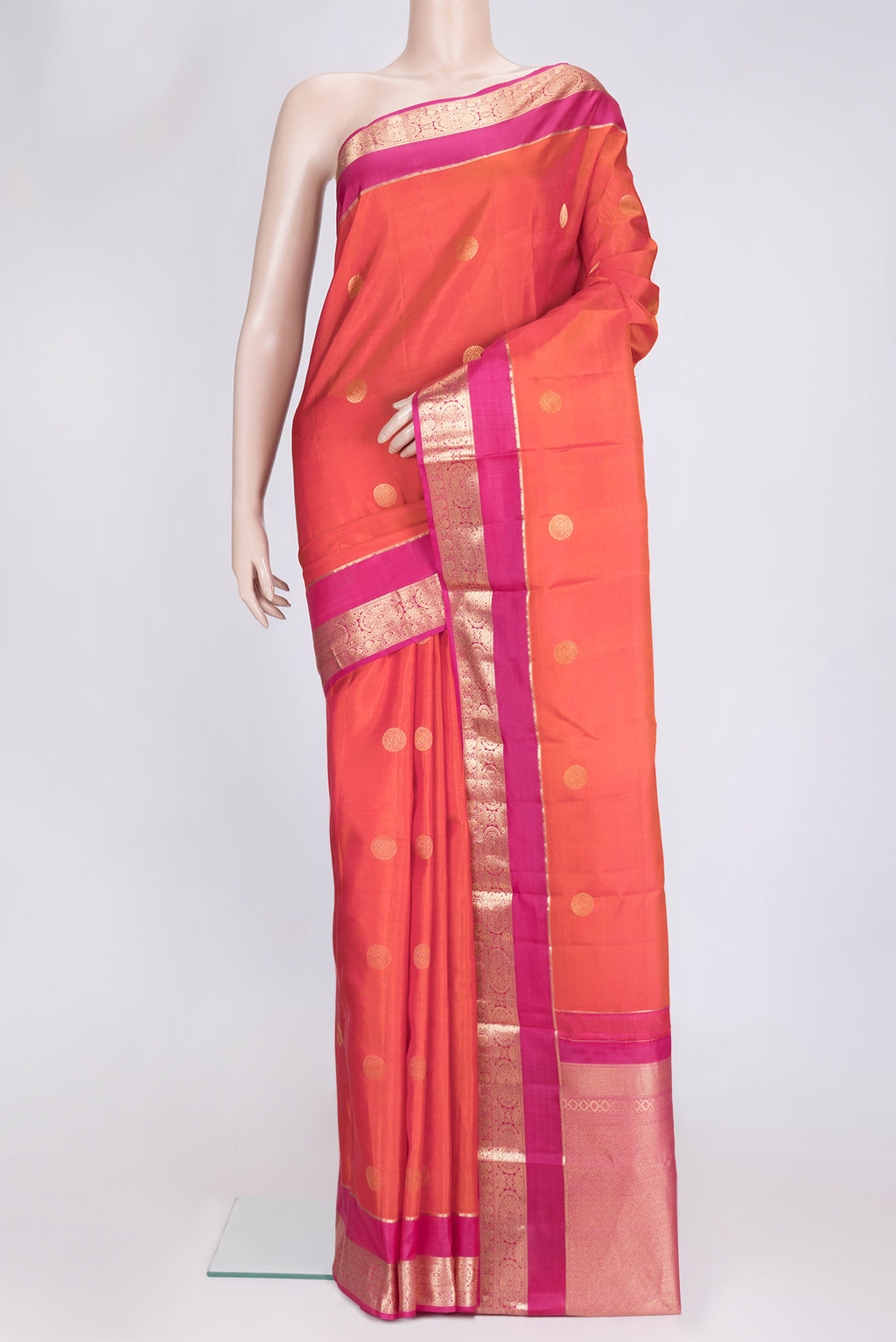 Orange Dual Tone Kanchipuram Silk Saree with Zari Butta on the body and Zari Border.  displayed on a mannequin