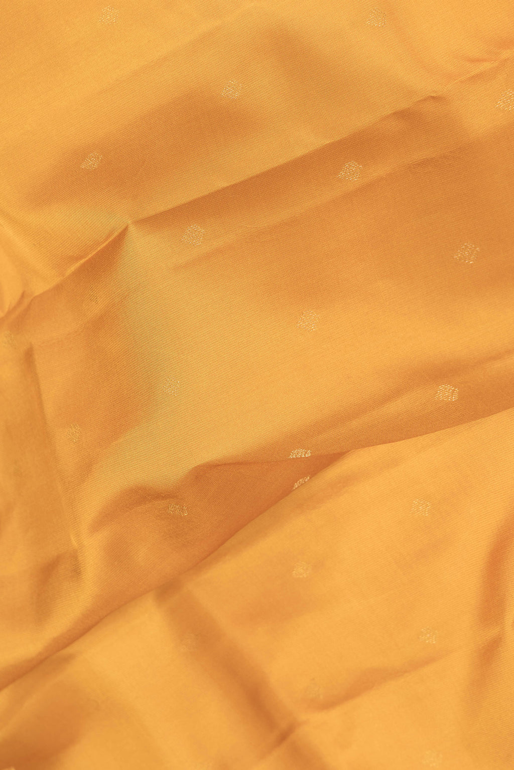 Close up of Mustard Dual Tone Kanchipuram Silk Saree with Zari Butta on the body and Zari Border.  displaying folds