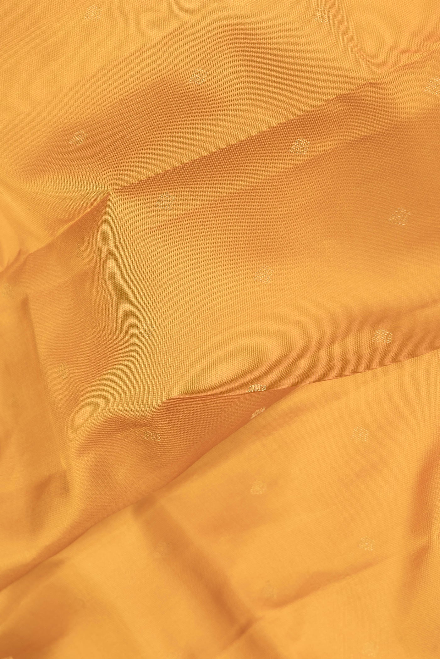 Close up of Mustard Dual Tone Kanchipuram Silk Saree with Zari Butta on the body and Zari Border.  displaying folds