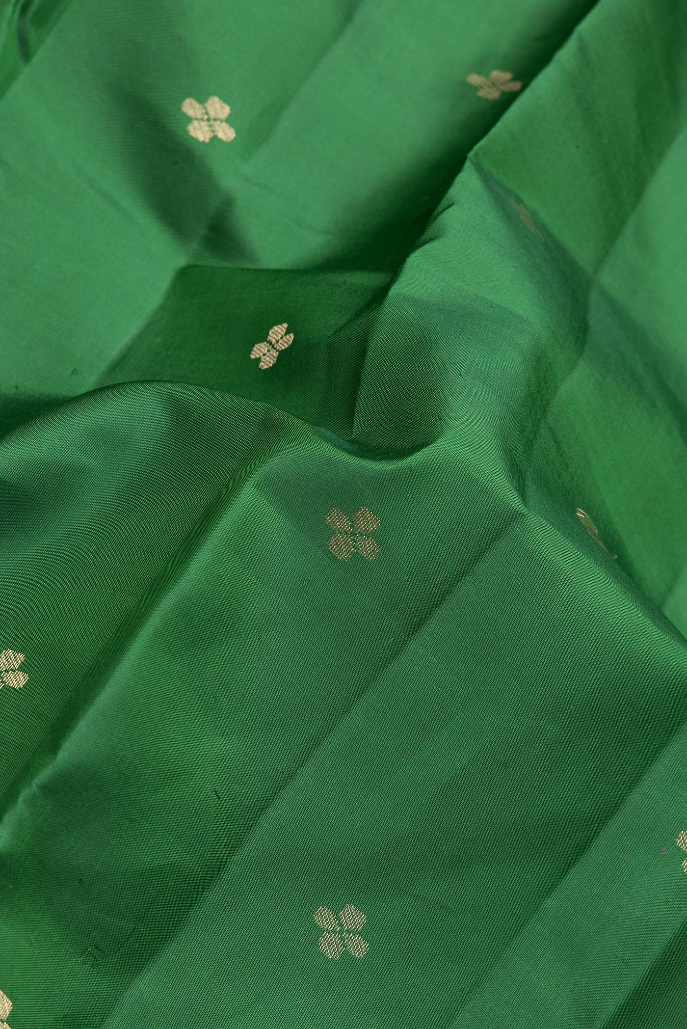 Close up of Bottle Green Dual Tone Kanchipuram Silk Saree with Zari Butta on the body and Zari And Thread Border.  displaying folds