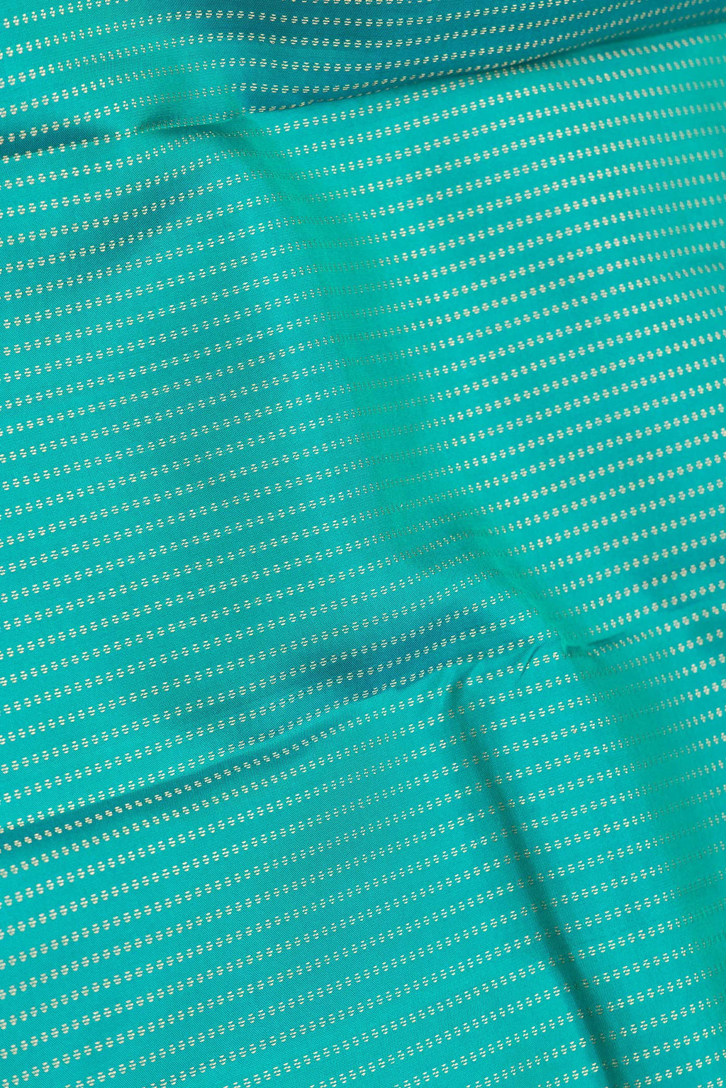 Close up of Green Dual Tone Kanchipuram Silk Saree with Stripes on the body and Zari Border.  displaying folds