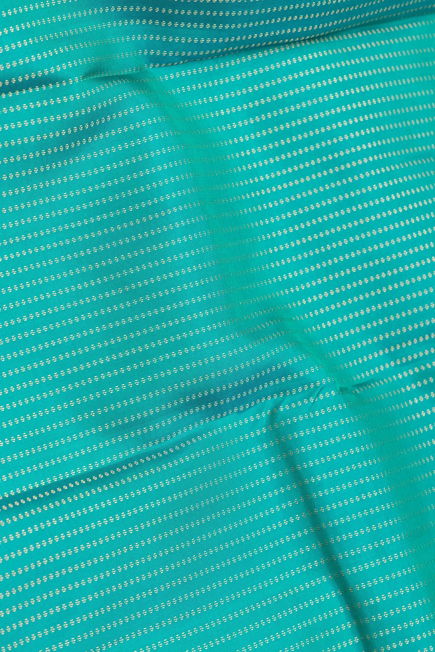 Close up of Green Dual Tone Kanchipuram Silk Saree with Stripes on the body and Zari Border.  displaying folds