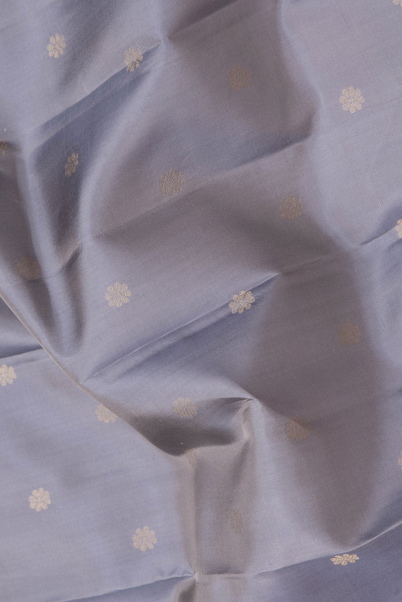Close up of Grey Dual Tone Kanjivaram Silk Saree with Zari Butta on the body and Zari Border.  displaying folds