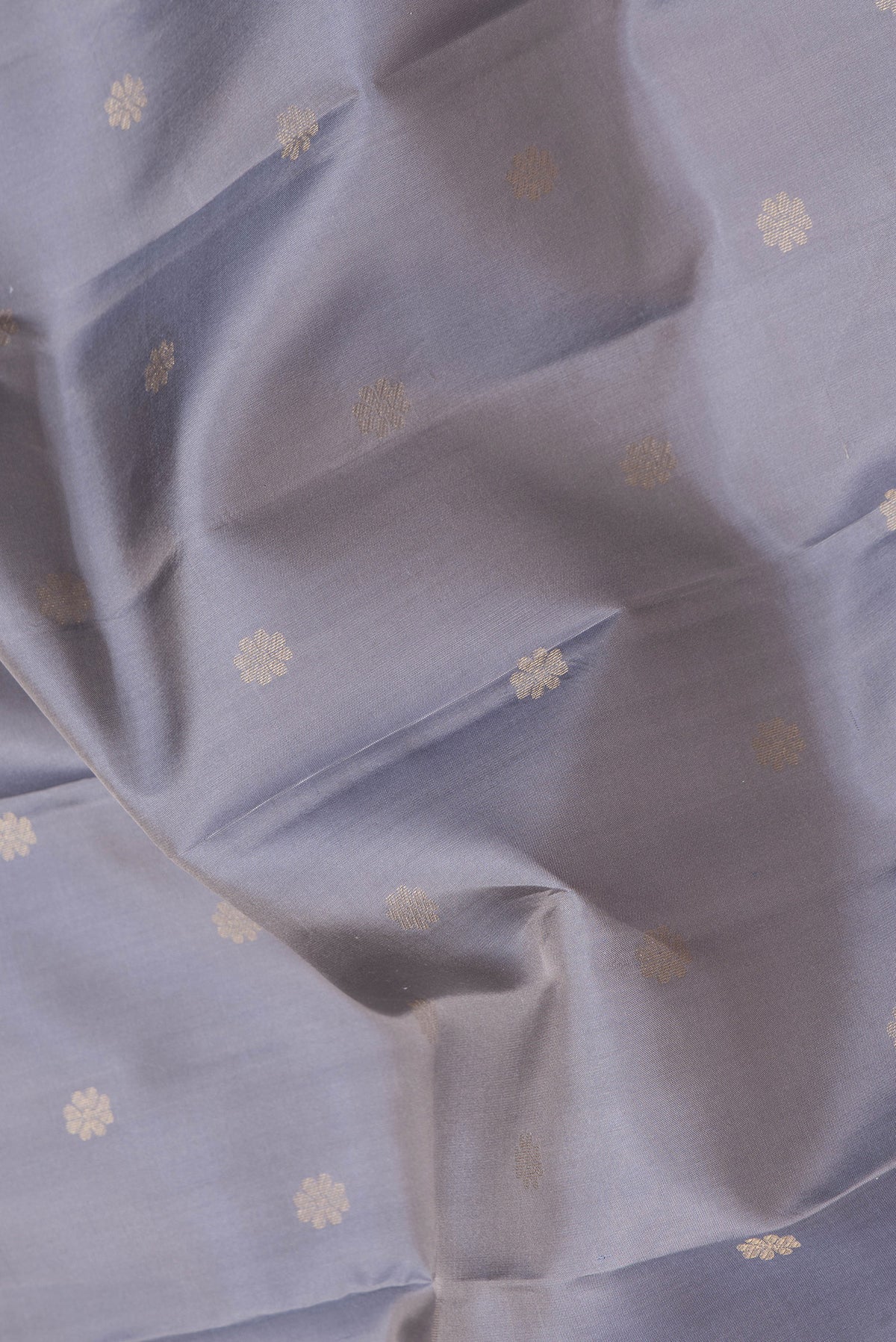 Close up of Grey Dual Tone Kanjivaram Silk Saree with Zari Butta on the body and Zari Border.  displaying folds