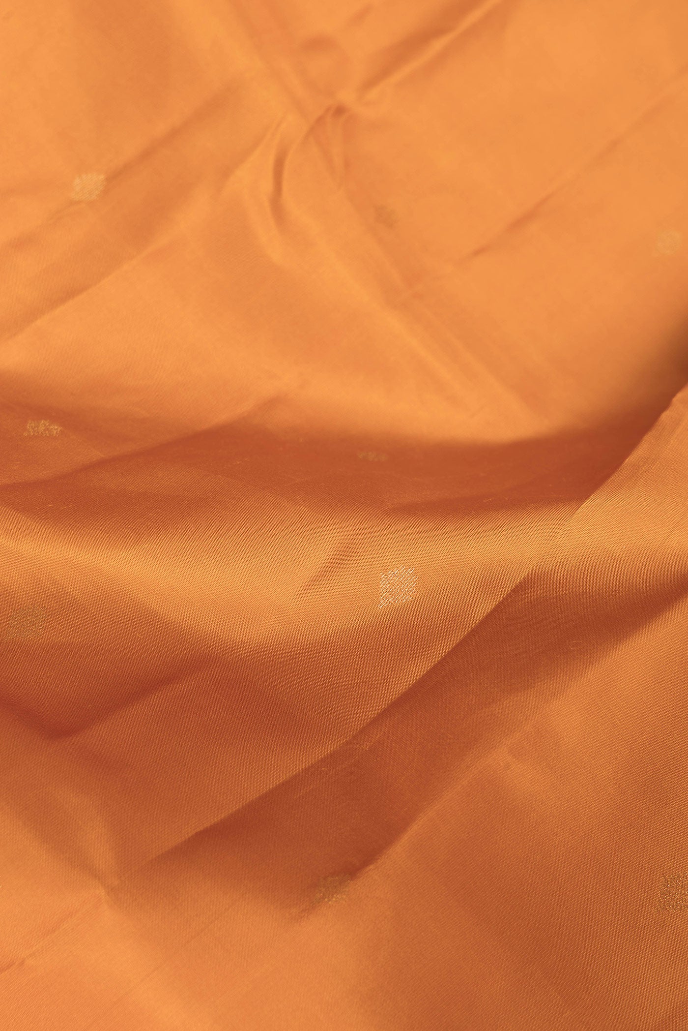 Close up of Mustard Dual Tone Kanchipuram Silk Saree with Zari Butta on the body and Zari Border.  displaying folds