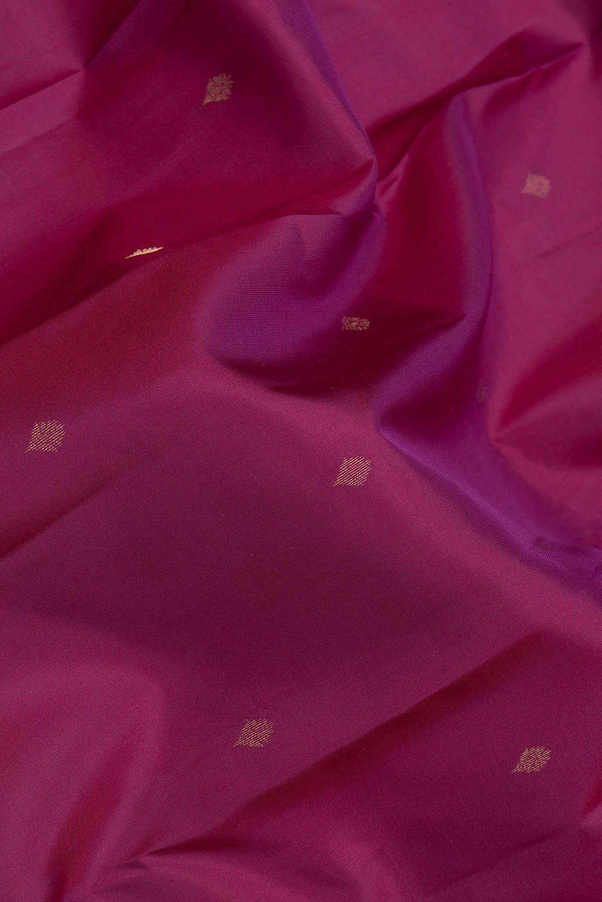 Close up of Magenta Dual Tone Kanchipuram Silk Saree with Zari Butta on the body and Zari Border.  displaying folds