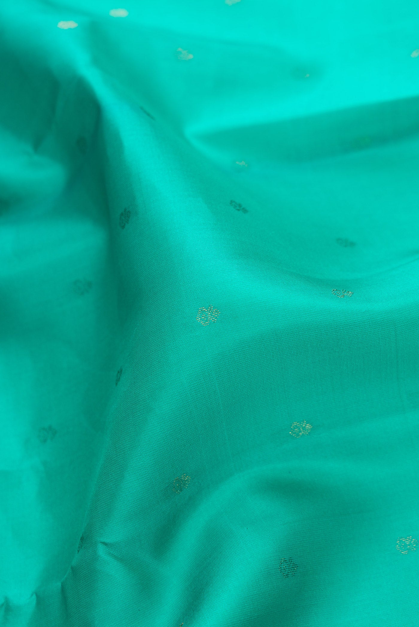 Close up of Sea Green Dual Tone Kanchipuram Silk Saree with Zari Butta on the body and Zari And Thread Border.  displaying folds