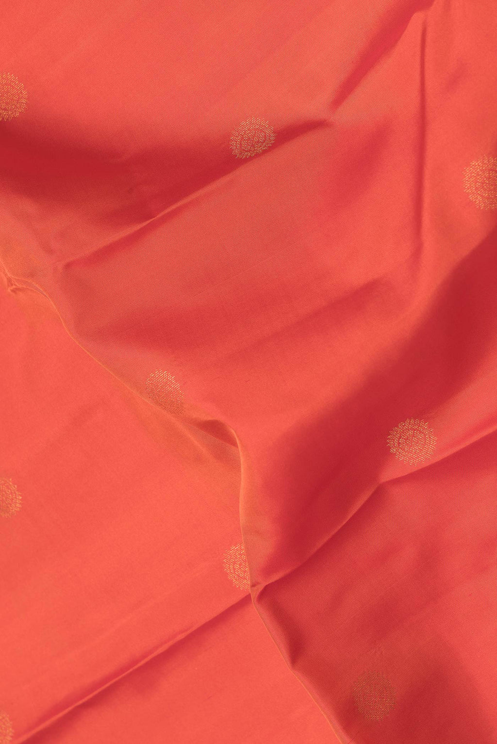 Close up of Orange Dual Tone Kanchipuram Silk Saree with Zari Butta on the body and Zari Border.  displaying folds