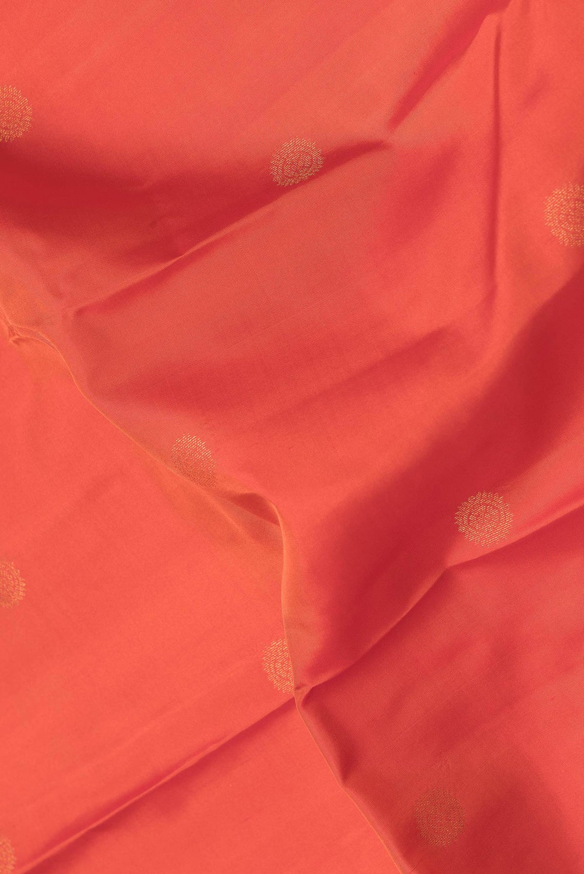 Close up of Orange Dual Tone Kanchipuram Silk Saree with Zari Butta on the body and Zari Border.  displaying folds