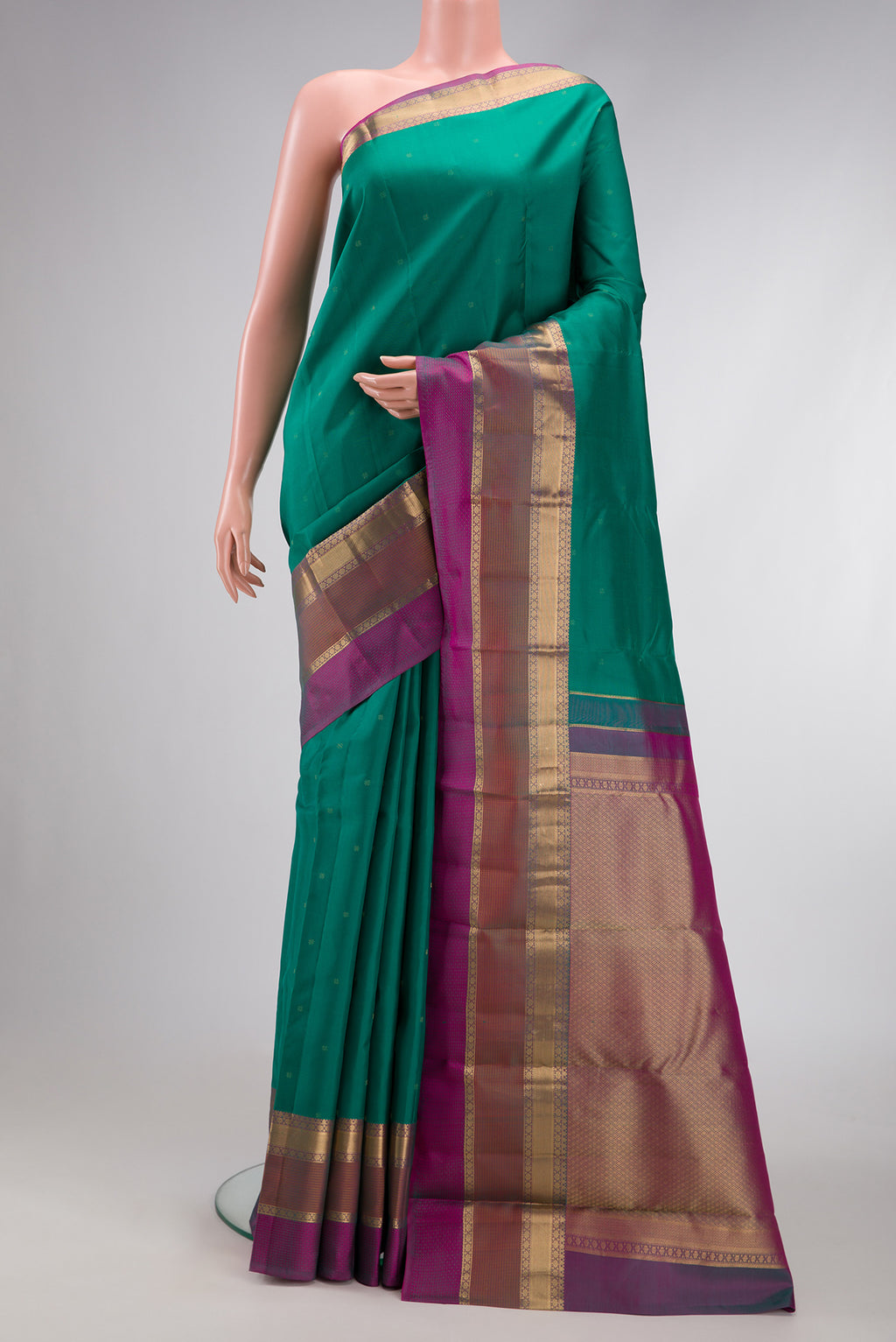 Green Dual Tone Kanchipuram Silk Saree with Zari Butta on the body and Zari Border.  displayed on a mannequin