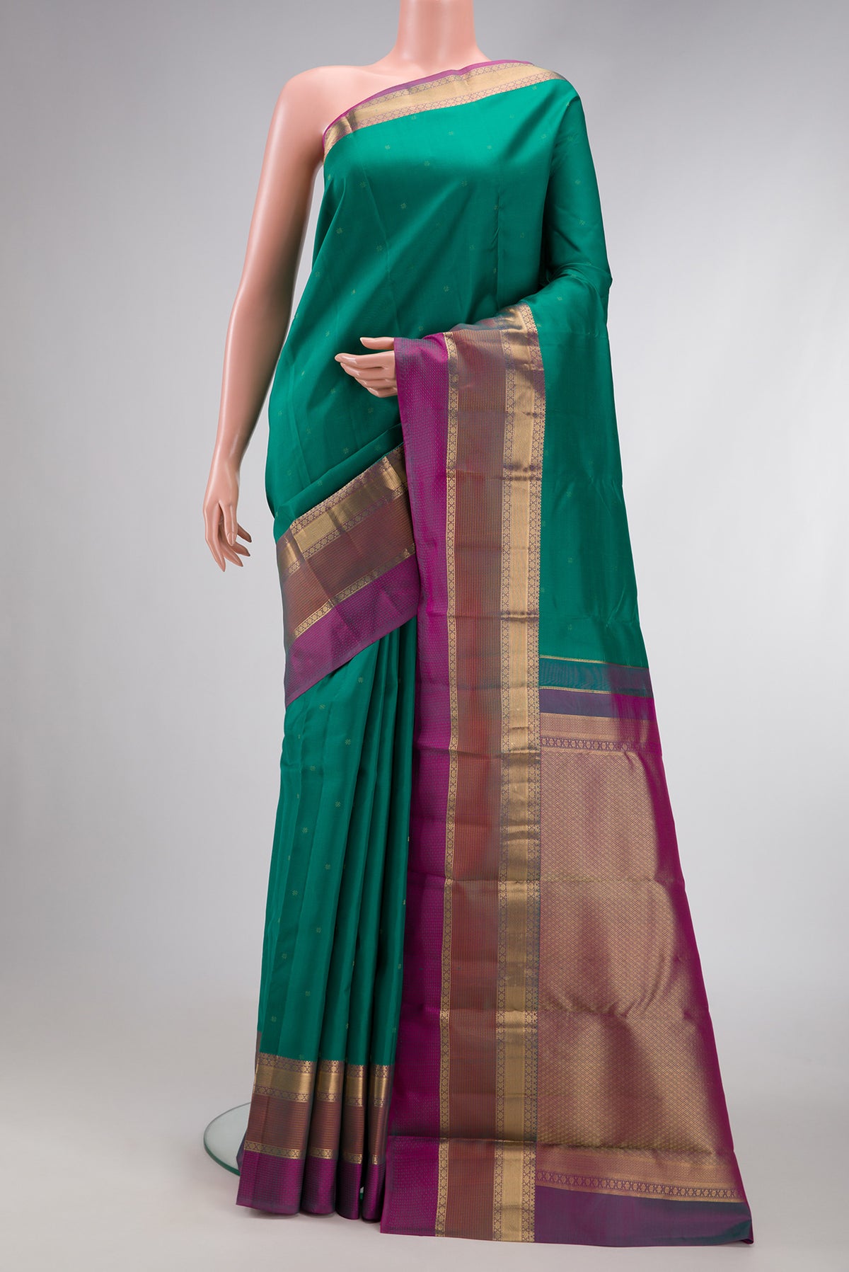 Green Dual Tone Kanchipuram Silk Saree with Zari Butta on the body and Zari Border.  displayed on a mannequin
