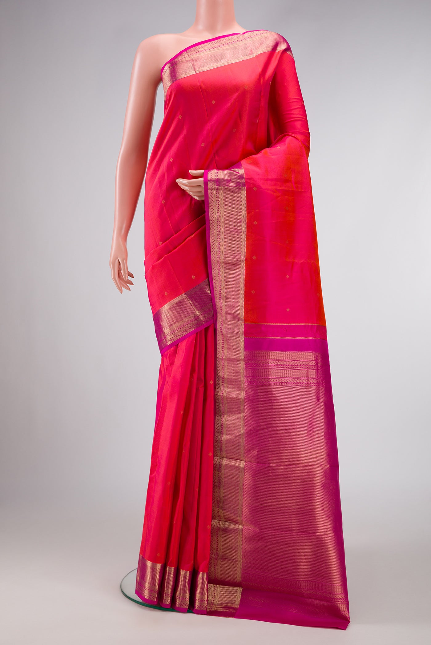 Coral Dual Tone Kanchipuram Silk Saree with Zari Butta on the body and Zari Border.  displayed on a mannequin